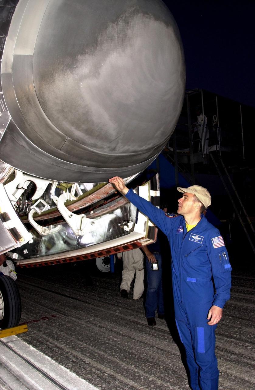 KENNEDY SPACE CENTER, FLA. --  During a post-flight walk around orbiter Columbia at the Shuttle Landing Facility, STS-109 Pilot Duane Carey gingerly checks the heat of the nose cone.   The crew returned to Earth after an 11-day mission  servicing the Hubble Space Telescope.  Wheel stop occurred on orbit 165 at 4:33:09 a.m. EST.  Main gear touchdown occurred at 4:31:52 a.m. and nose wheel touchdown at 4:32:02.  Rollout time was 1 minute, 17 seconds.   This was the 58th landing at KSC out of 108 missions in the history of the Shuttle program