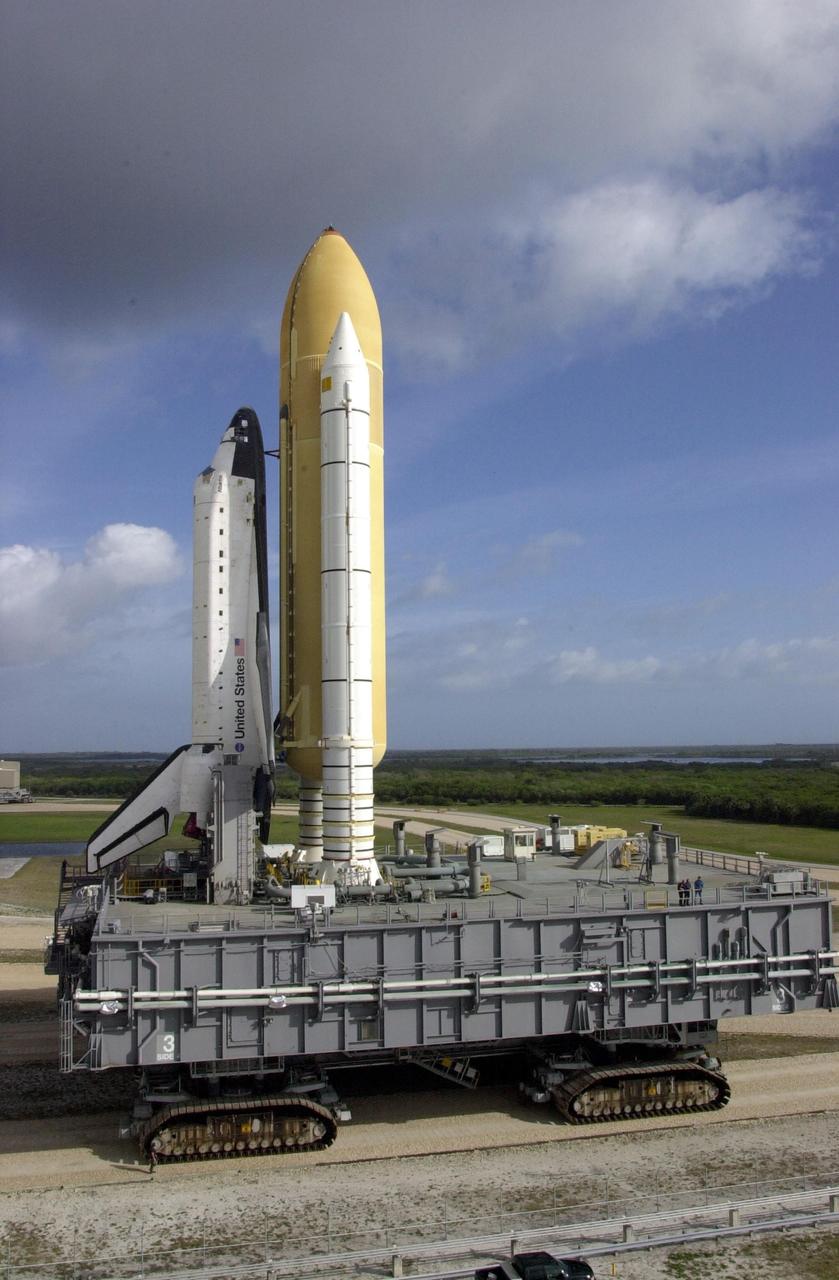 KENNEDY SPACE CENTER, FLA. - Sitting atop the Mobile Launcher Platform, Space Shuttle Atlantis towers above the workers aboard.  The Shuttle and MLP rest on top of the crawler-transporter beneath it, which moves about 1 mile per hour. Atlantis is scheduled for launch April 4 on mission STS-110, which will install the S0 truss, the framework that eventually will hold the power and cooling systems needed for future international research laboratories on the International Space Station.  The  Canadarm2 robotic arm will be used exclusively to hoist the 13-ton truss from the payload bay to the Station.  The S0 truss will be the first major U.S. component launched to the Station since the addition of the Quest airlock in July 2001.  The four spacewalks planned for the construction will all originate from the airlock.  The mission will be Atlantis' 25th trip to space