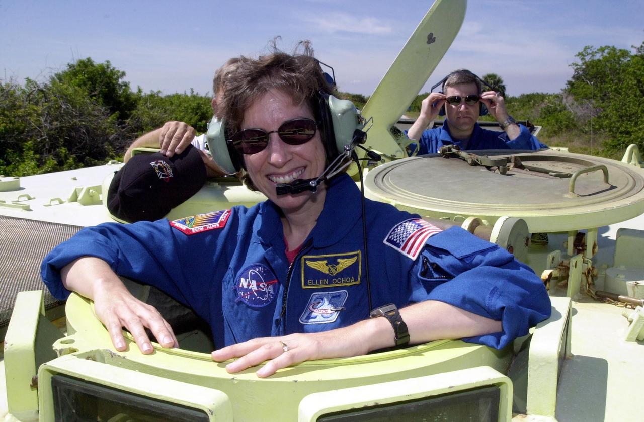 KENNEDY SPACE CENTER, FLA. --  STS-110 Mission Specialist Ellen Ochoa waits her turn at driving the M-113 armored personnel carrier, part of Terminal Countdown Demonstration Test activities.  In the background, right,  is Pilot Stephen Frick.  TCDT includes emergency egress training and a simulated launch countdown. The TCDT is held at KSC prior to each Space Shuttle flight.  Scheduled for launch April 4, the 11-day mission will feature Shuttle Atlantis docking with the International Space Station (ISS) and delivering the S0 truss, the centerpiece-segment of the primary truss structure that will eventually extend over 300 feet