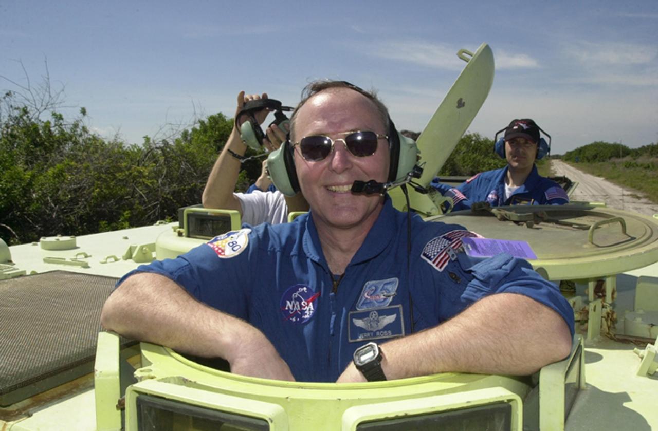 KENNEDY SPACE CENTER, FLA. --  STS-110 Mission Specialist Jerry Ross waits his turn at driving the M-113 armored personnel carrier, part of Terminal Countdown Demonstration Test activities.  In the background, right, is Mission Specialist Lee Morin.  TCDT includes emergency egress training and a simulated launch countdown, and is held at KSC prior to each Space Shuttle flight.  Scheduled for launch April 4, the 11-day mission will feature Shuttle Atlantis docking with the International Space Station (ISS) and delivering the S0 truss, the centerpiece-segment of the primary truss structure that will eventually extend over 300 feet