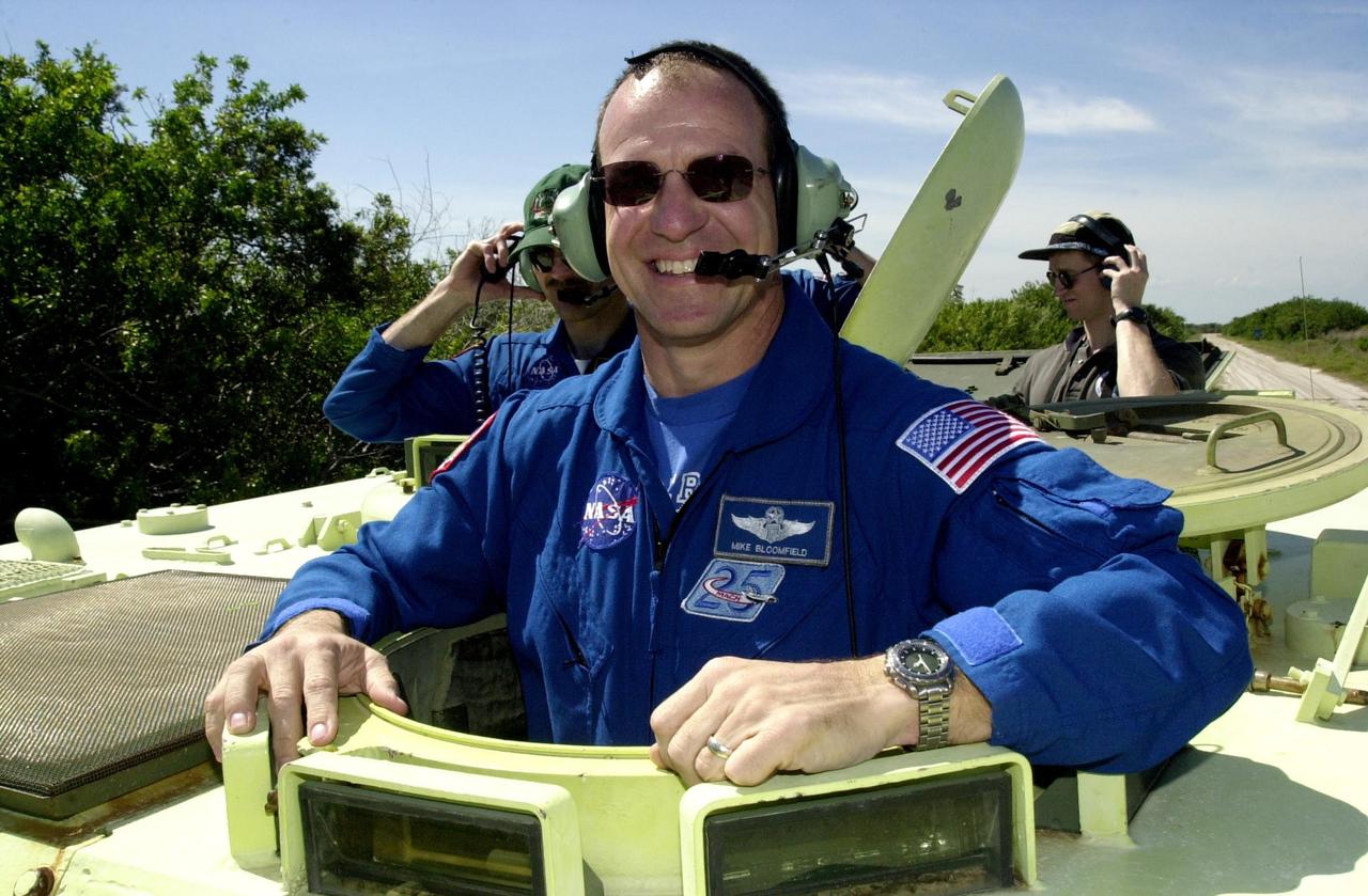 KENNEDY SPACE CENTER, FLA. --   STS-110 Commander Michael Bloomfield is eager to take his turn turn at driving the M-113 armored personnel carrier, part of Terminal Countdown Demonstration Test activities.  To his left is Mission Specialist Steven Smith. TCDT includes emergency egress training and a simulated launch countdown, and is held at KSC prior to each Space Shuttle flight.  Scheduled for launch April 4, the 11-day mission will feature Shuttle Atlantis docking with the International Space Station (ISS) and delivering the S0 truss, the centerpiece-segment of the primary truss structure that will eventually extend over 300 feet