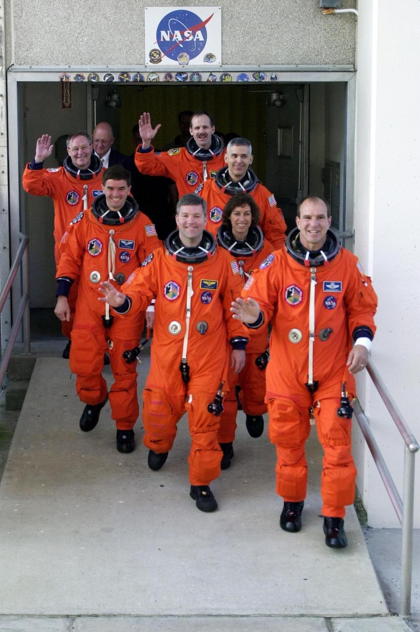 KENNEDY SPACE CENTER, FLA. --  The STS-110 crew walks out of the Operations and Checkout Building on their way to the launch pad for a simulated launch countdown.  From the rear, left row, are Mission Specialists Jerry Ross and Rex Walheim, Pilot Stephen Frick; right row, Mission Specialists Steven Smith, Lee Morin and Ellen Ocho, and Commander Michael Bloomfield.  The simulation is part of Terminal Countdown Demonstration Test activities.  TCDT also includes emergency egress training and is held at KSC prior to each Space Shuttle flight.  Scheduled for launch April 4, the 11-day mission will feature Shuttle Atlantis docking with the International Space Station (ISS) and delivering the S0 truss, the centerpiece-segment of the primary truss structure that will eventually extend over 300 feet