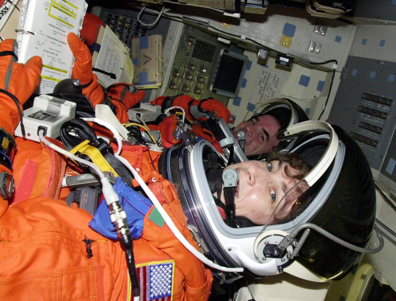 KENNEDY SPACE CENTER, FLA. --  Settling into their seats in Space Shuttle Atlantis are STS-110 Mission Specialists Rex Walheim and Ellen Ochoa as they prepare for a simulated launch countdown. The simulation is part of Terminal Countdown Demonstration Test activities.  TCDT also includes emergency egress training and is held at KSC prior to each Space Shuttle flight.  Scheduled for launch April 4, the 11-day mission will feature Shuttle Atlantis docking with the International Space Station (ISS) and delivering the S0 truss, the centerpiece-segment of the primary truss structure that will eventually extend over 300 feet