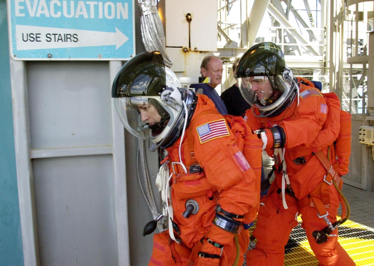 KENNEDY SPACE CENTER, FLA. - As part of emergency egress training, STS-110 Mission Specialists Ellen Ochoa and Rex J. Walheim make their way to the slidewire basket on the Fixed Service Structure. The crew is taking part in Terminal Countdown Demonstration Test activities, which also include a simulated launch countdown, held at KSC prior to each Space Shuttle flight.  Scheduled for launch April 4, the 11-day mission will feature Shuttle Atlantis docking with the International Space Station (ISS) and delivering the S0 truss, the centerpiece-segment of the primary truss structure that will eventually extend over 300 feet.