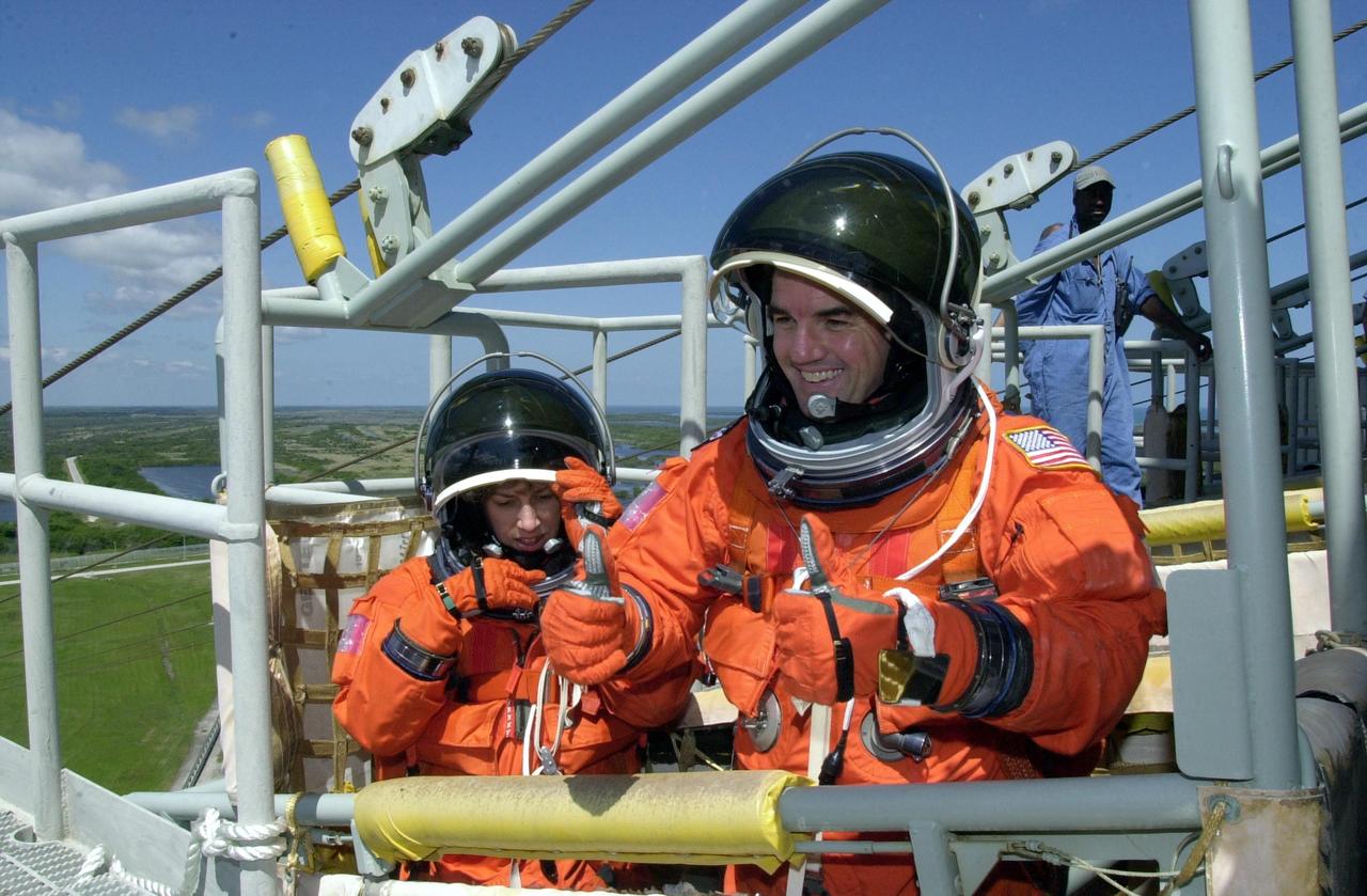 KENNEDY SPACE CENTER, FLA. -- STS-110 Mission Specialists Ellen Ochoa and Rex J. Walheim are in the slidewire basket, part of emergency egress equipment on the launch pad. The crew is taking part in Terminal Countdown Demonstration Test activities, which also include a simulated launch countdown, held at KSC prior to each Space Shuttle flight.  Scheduled for launch April 4, the 11-day mission will feature Shuttle Atlantis docking with the International Space Station (ISS) and delivering the S0 truss, the centerpiece-segment of the primary truss structure that will eventually extend over 300 feet.