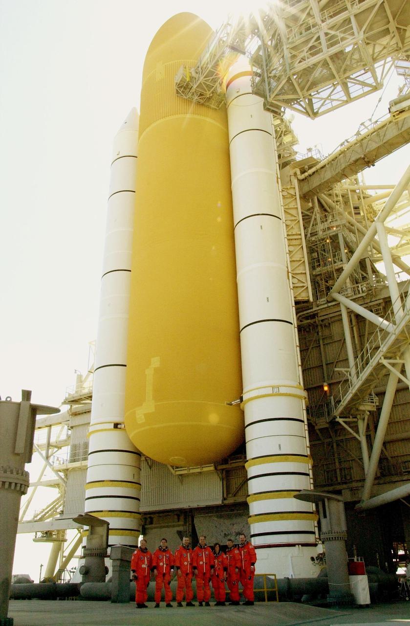 KENNEDY SPACE CENTER, FLA. --   Dwarfed by the external tank and solid rocket boosters of Space Shuttle Atlantis is the STS-110 crew.  Standing left to right are Mission Specialists Jerry Ross, Rex Walheim and Lee Morin; Commander Michael Bloomfield; Mission Specialist Ellen Ochoa; Pilot Stephen Frick; and Mission Specialist Steven Smith.  The crew is taking a break during Terminal Countdown Demonstration Test activities to pose for the photo. The TCDT, which includes emergency egress training and a simulated launch countdown, is held at KSC prior to each Space Shuttle flight.  Scheduled for launch April 4, the 11-day mission will feature Shuttle Atlantis docking with the International Space Station (ISS) and delivering the S0 truss, the centerpiece-segment of the primary truss structure that will eventually extend over 300 feet