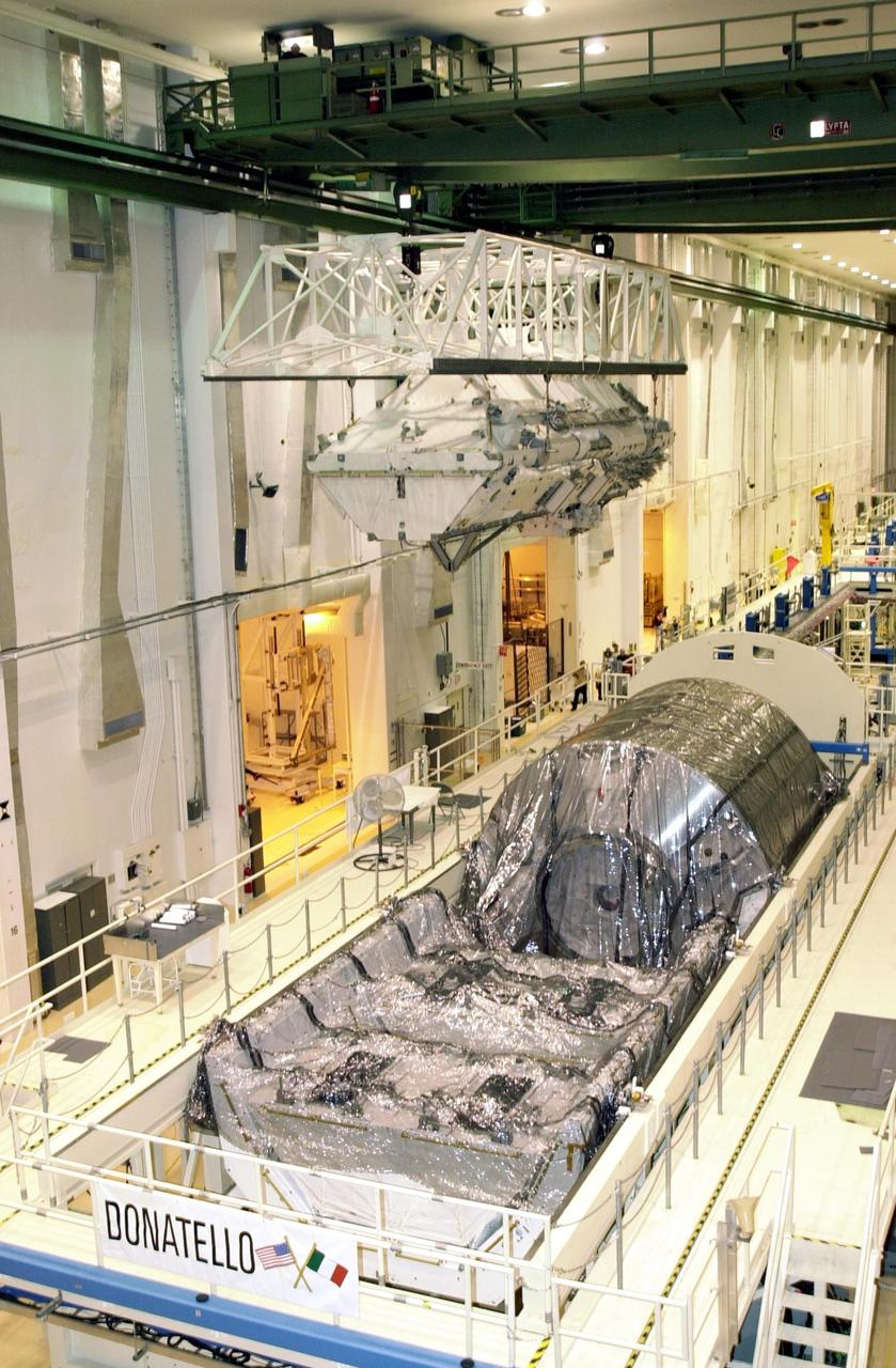 KENNEDY SPACE CENTER, FLA. -- In the Operations and Checkout Building, an overhead crane carries the Integrated Truss Structure S0 to the payload canister which will transport it to the launch pad for mission STS-110.  Seen below the truss is the Multi-Purpose Logistics Module Donatello, currently not in use. The S0 truss will be part of the payload on Space Shuttle Atlantis. The S0 truss will be attached to the U.S. Lab, "Destiny,"  on the 11-day mission, becoming the backbone of the orbiting International Space Station (ISS). Launch is scheduled for April 4