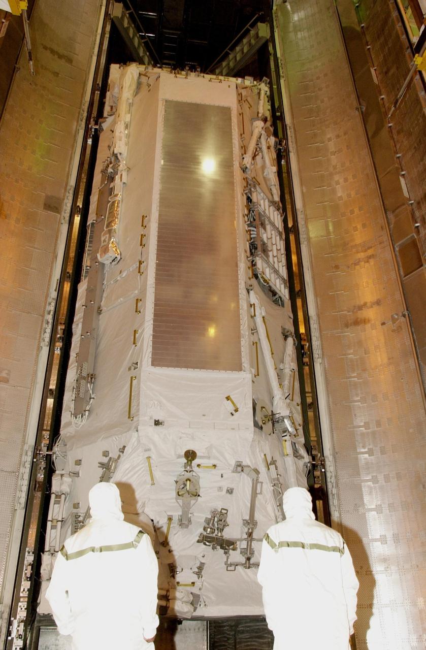 KENNEDY SPACE CENTER, FLA. - In the payload changeout room, workers watch as the doors of the payload canister open to reveal the S0 Integrated Truss Structure.   The truss will be moved into the PCR and then transferred to Space Shuttle Atlantis's payload bay. Part of the payload on mission STS-110, the S0 truss will become the backbone of the orbiting International Space Station (ISS).  The S0 truss will be attached to the U.S. Lab, "Destiny,"  on the 11-day mission.    Launch is scheduled for April 4