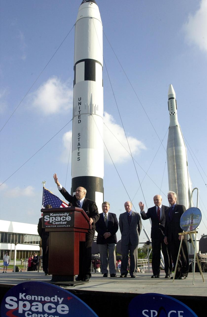 KENNEDY SPACE CENTER, FLA. --   During opening ceremonies for the 40th anniversary celebration of American spaceflight, Rick Abramson, president of Delaware North Parks Services of Spaceport, Inc., waves to the spectators.  Behind him are four of the space pioneers being honored: (from left) Wally Schirra, Gordon Cooper, John Glenn Jr. and Scott Carpenter.  Next to Carpenter stands a commemorative painting of a Mercury rocket launch that the four signed.  The ceremonies were held in the KSC Visitor Complex Rocket Garden. The event was capped with a dinner held at the KSC Apollo/Saturn V Center