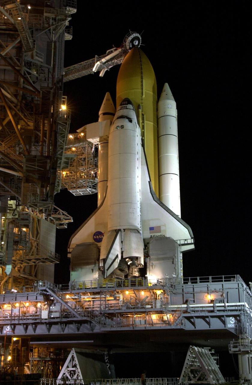 KENNEDY SPACE CENTER, FLA. -- Space Shuttle Atlantis is revealed as the Rotating Service Structure rolls back into launch position. The RSS provides protected access to the orbiter for changeout and servicing of payloads at the pad. The structure has access platforms at five levels to provide access to the payload bay. The Shuttle rests on the Mobile Launcher Platform (MLP), which straddles the flame trench below. The flame trench is part of the Flame Deflector System that insulates pad structures from the intense heat of the launch. Above the golden external tank is the vent hood (known as the "beanie cap") at the end of the gaseous oxygen vent arm. Vapors are created as the liquid oxygen in the external tank boil off. The hood vents the gaseous oxygen vapors away from the Space Shuttle vehicle. Mission STS-110 is scheduled to launch April 4 on its 11-day mission to the International Space Station