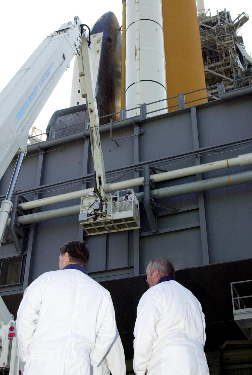 KENNEDY SPACE CENTER, FLA. --  At Launch Pad 39B, an inspection team gathers at the foot of Mobile Launcher Platform where Space Shuttle Atlantis sits. Earlier today a leak in a ground support liquid hydrogen vent line on the south side of the Mobile Launcher Platform caused a scrub of the launch of Atlantis on mission STS-110.  An engineering team is assessing the situation to determine the best method to repair the hydrogen line.  The turnaround plan includes time to perfor weld repairs and return the vehicle to a timeline to resume the countdown