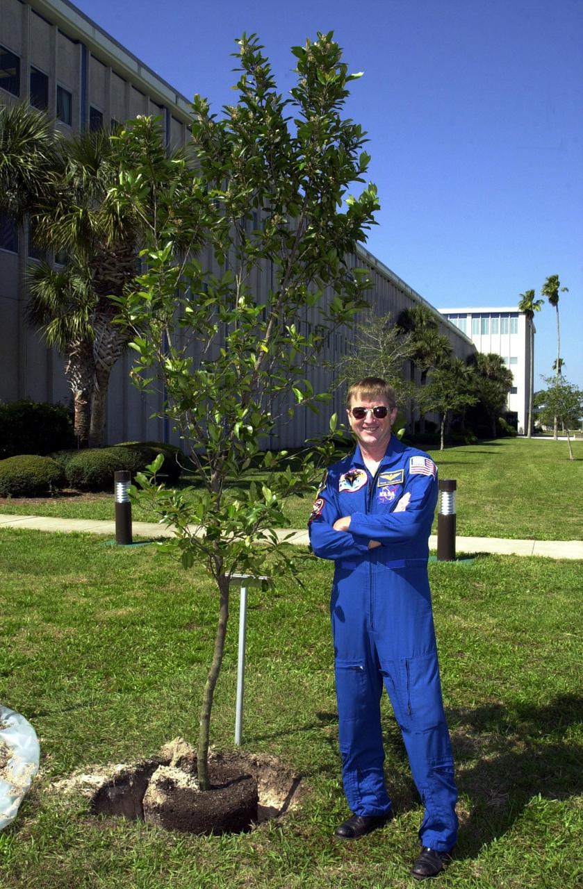 KENNEDY SPACE CENTER, FLA. -- Astronaut Frank Culbertson stands next to the cherry laurel tree he has dedicated and helped plant near KSC Headquarters Building. The tree commemorates his stay on and safe return from the International Space Station as a member of the Expedition 3 crew.   Culbertson served as commander for the four-month stay, August to December 2001.  The tree planting is a tradition for the Expedition crews.    