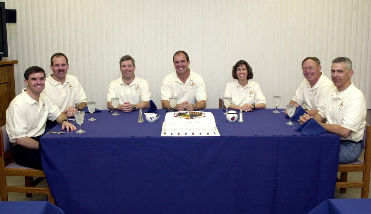 KENNEDY SPACE CENTER, FLA. --  The STS-110 crew relaxes at the traditional crew meal before getting ready for launch later in the day.  Seated, from left, are Mission Specialits Rex J. Walheim and Steven L. Smith; Pilot Stephen N. Frick; Commander Michael J. Bloomfield; and Mission Specialists Ellen Ochoa, Jerry L. Ross and Lee M.E. Morin.  The cake on the table is also traditional, featuring the mission patch.  STS-110 is the 13th assembly flight to the International Space Station, carrying the S0 Integrated Truss Structure and Mobile Transporter (MT). On the 11-day mission, the mission features four spacewalks to attach the S0 truss, which will become the backbone of the Space Station, to the U.S. Lab, "Destiny."   The  MT, a space "railcar," is attached to the truss segment and will make its debut run during the flight.    Among the seven astronauts, Walheim and Frick are making their first Shuttle flight; Ross is making a record-breaking seventh flight.  Launch is scheduled for 4:40 p.m. EDT April 8