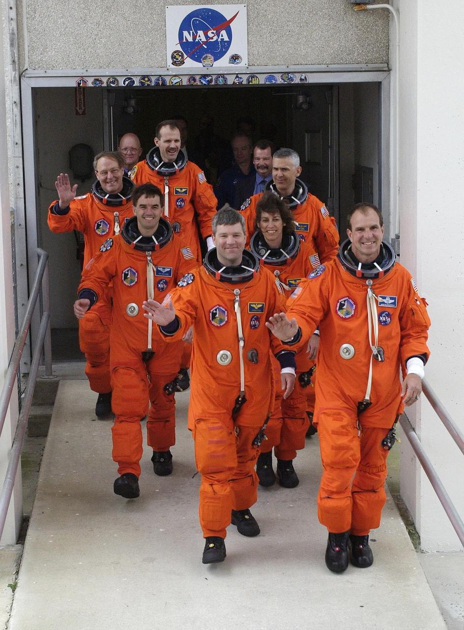 KENNEDY SPACE CENTER, FLA. - Showing their eagerness for launch, the STS-110 crew wave as they stride out of the Operations and Checkout Building.  Leading the way in the front row are Pilot Stephen N. Frick (left) and Commander Michael J. Bloomfield (right); in the second row are Mission Specialists Rex J. Walheim and Ellen Ochoa; third row, Jerry L. Ross and Lee M.E. Morin; in the rear is Mission Specialist Steven L. Smith. STS-110 is the 13th assembly flight to the International Space Station, carrying the S0 Integrated Truss Structure and Mobile Transporter (MT).  On the 11-day mission, the mission features four spacewalks to attach the S0 truss, which will become the backbone of the Space Station, to the U.S. Lab, "Destiny."   The  MT, a space "railcar," is attached to the truss segment and will make its debut run during the flight.  Launch is scheduled for 4:40 p.m. EDT (20:40 GMT).  Photo by Scott Andrews