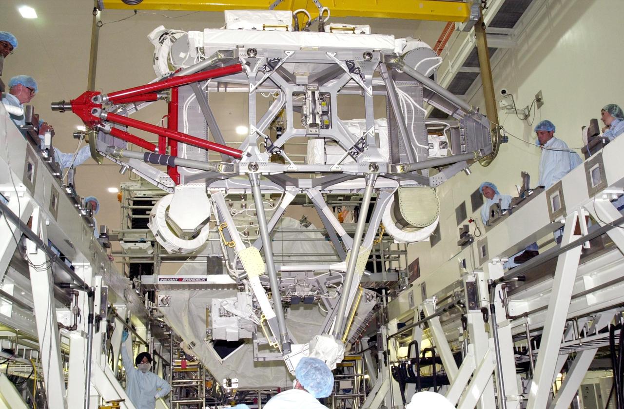 KENNEDY SPACE CENTER, FLA. -- In the Space Station Processing Facility, overhead cranes lower the Mobile Base System onto the weight and center of gravity stand.  Part of the payload on mission STS-111 to the International Space Station, the MBS will be installed on the Mobile Transporter to complete the Canadian Mobile Servicing System, or MSS. The mechanical arm will then have the capability to "inchworm" from the U.S. Lab Destiny to the MSS and travel along the truss to work sites.  STS-111 is the second utilization flight (UF-2) to the Space Station and will also carry the Expedition 5 crew to replace Expedition 4.  Launch is scheduled for May 31, 2002