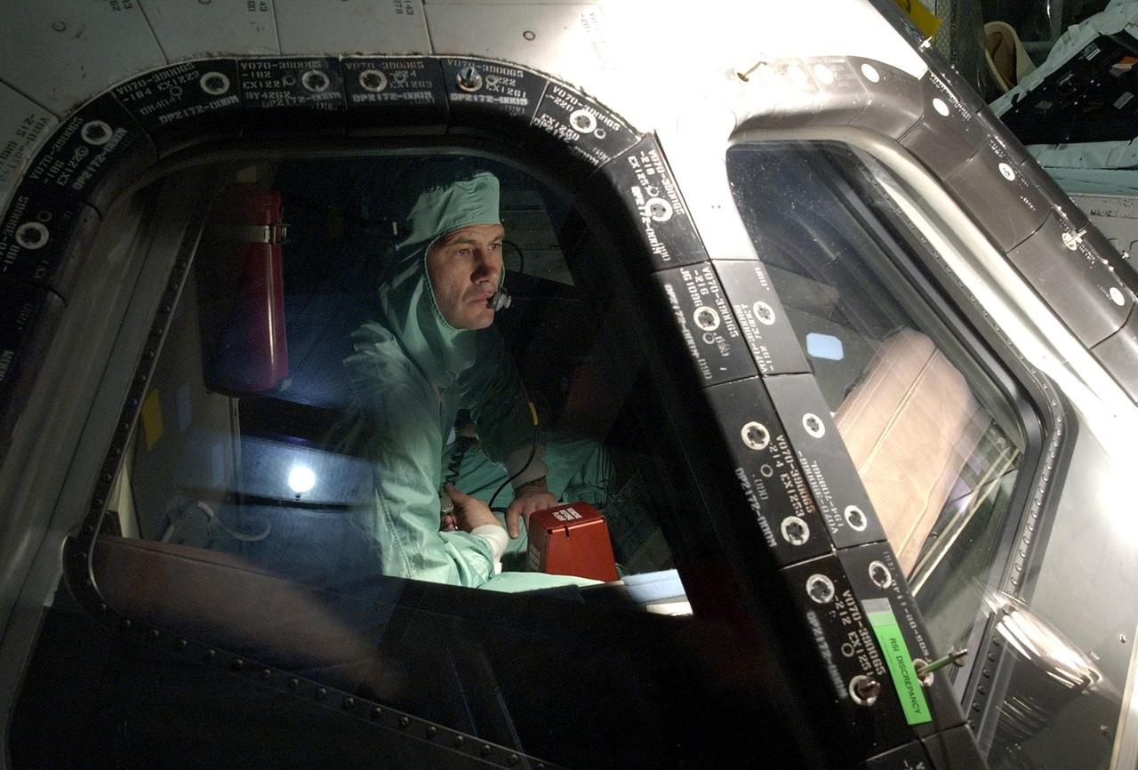 KENNEDY SPACE CENTER, FLA. -- In the Orbiter Processing Facility, STS-111 Pilot Paul Lockhart inspects the window of Endeavour's cockpit.  He and other crew members are taking part in a Crew Equipment Interface Test in preparation for launch.  Mission STS-111 will carry to the International Space Station the Multipurpose Logistics Module (MPLM), filled with experiment racks and three stowage and resupply racks, and the Mobile Base System (MBS), which will attach to the Mobile Transporter and complete the Canadian Mobile Servicing System, or MSS. The Station's mechanical arm will then have the capability to "inchworm" from the U.S. Lab to the MSS and travel along the truss to work sites on the Station.  Launch of Endeavour on mission STS-111 is scheduled for May 30, 2002