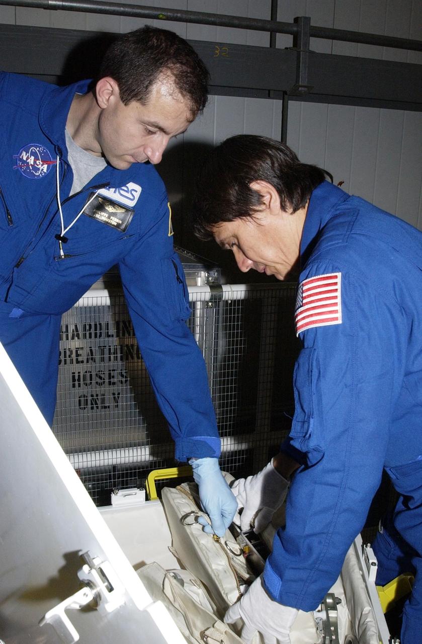 KENNEDY SPACE CENTER, FLA. -- In the Orbiter Processing Facility, STS-111 Mission Specialists Phillippe Perrin (left) and Franklin Chang-Diaz (right) check equipment for their mission.  Perrin is with the French Space Agency (CNES).  Perrin and Chang-Diaz, with other crew members, are taking part in a Crew Equipment Interface Test in preparation for launch.  Mission STS-111 will carry to the International Space Station the Multipurpose Logistics Module (MPLM), filled with experiment racks and three stowage and resupply racks, and the Mobile Base System (MBS), which will attach to the Mobile Transporter and complete the Canadian Mobile Servicing System, or MSS. The Station's mechanical arm will then have the capability to "inchworm" from the U.S. Lab to the MSS and travel along the truss to work sites on the Station.  Launch of Endeavour on mission STS-111 is scheduled for May 30, 2002