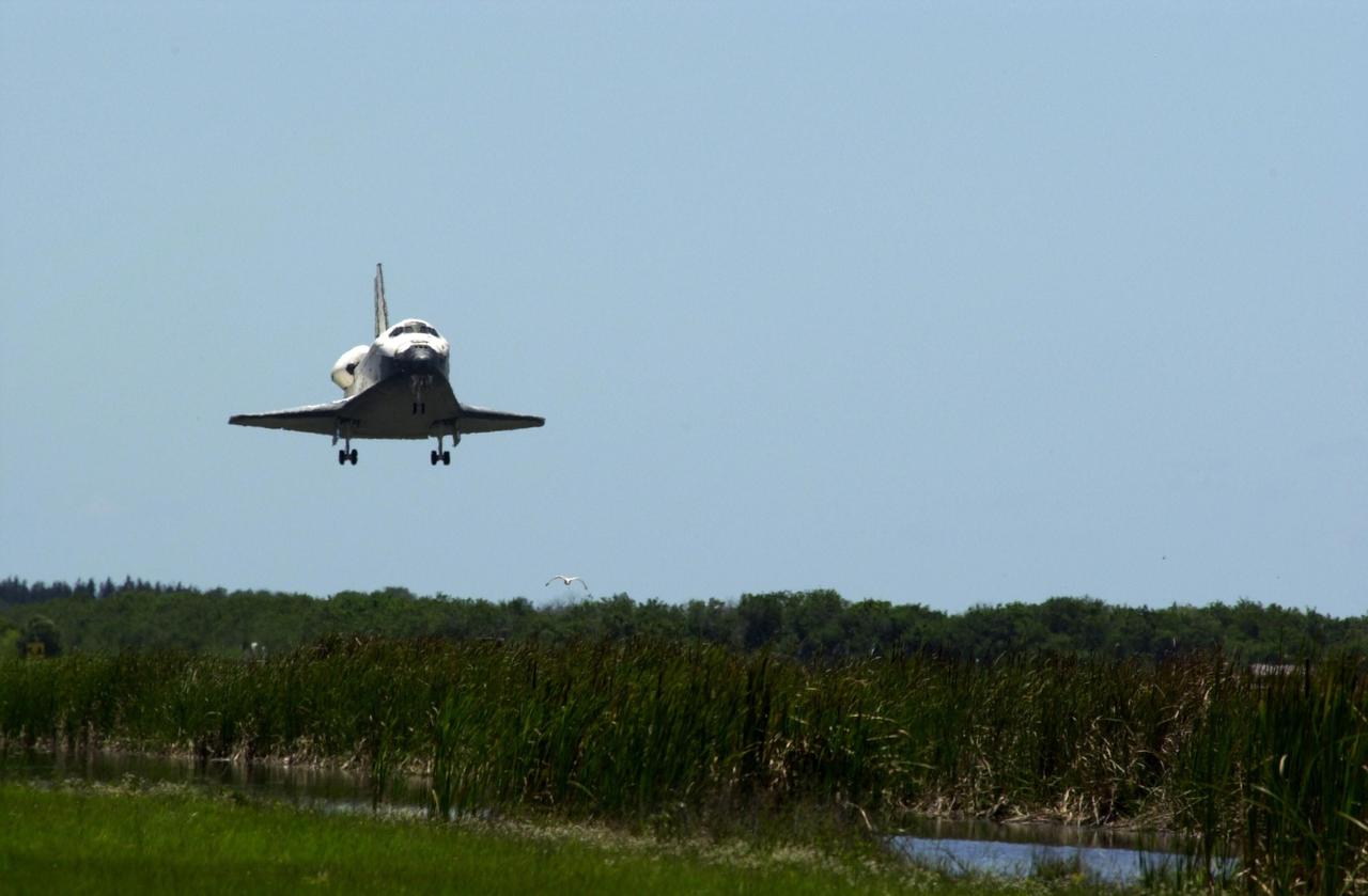KENNEDY SPACE CENTER, FLA. - Atlantis swoops down over vegetation and water as it approaches runway 33 at KSC's Shuttle Landing Facility.  The landing completes the 10-day, 19-hour, 4.5-million mile mission STS-110 to the International Space Station.. The orbiter carries the returning crew Commander Michael Bloomfield, Pilot Stephen Frick and Mission Specialists Jerry Ross, Steven Smith, Ellen Ochoa, Lee Morin and Rex Walheim.  Main gear touchdown was 12:26:57 p.m. EDT, nose gear touchdown was 12:27:09 p.m. and wheel stop was 12:28:07 p.m.  The crew delivered and installed the S0 truss, which will support cooling and power systems essential for the addition of future international laboratories, on the Station