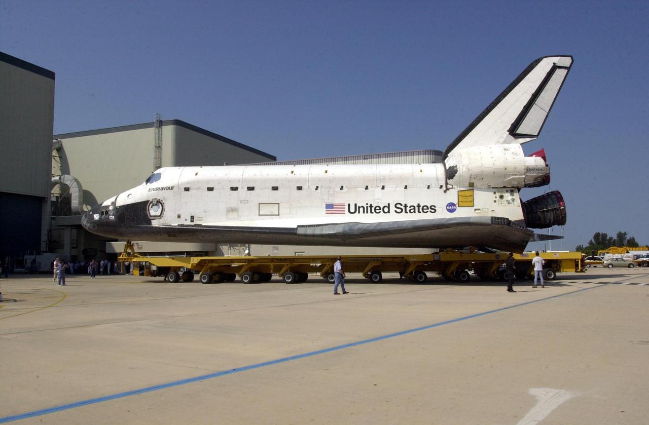 KENNEDY SPACE CENTER, FLA. -- Orbiter Endeavour is rolled out of the Orbiter Processing Facility atop a transporter. The orbiter is being moved to the Vehicle Assembly Building for mating to the External Tank/Solid Rocket Boosters atop the Mobile Launcher Platform. Endeavour is targeted to launch May 30, 2002, on mission STS-111 to the International Space Station. Mission goals include delivering and installing the Mobile Base System to complete the Canadian Mobile Service System and carrying the Expedition 5 crew to the Station for rotation with Expedition 4