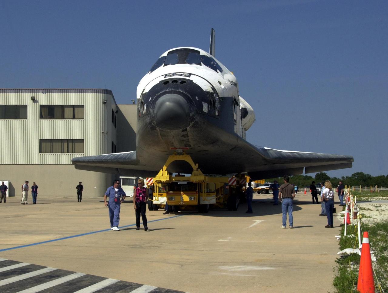 KENNEDY SPACE CENTER, FLA. - Employees at KSC walk alongside orbiter Endeavour as it rolls to the Vehicle Assembly Building. In the VAB it will be mated to the External Tank/Solid Rocket Boosters atop the Mobile Launcher Platform. Endeavour is targeted to launch May 30, 2002, on mission STS-111 to the International Space Station. Mission goals include delivering and installing the Mobile Base System to complete the Canadian Mobile Service System and carrying the Expedition 5 crew to the Station for rotation with Expedition 4