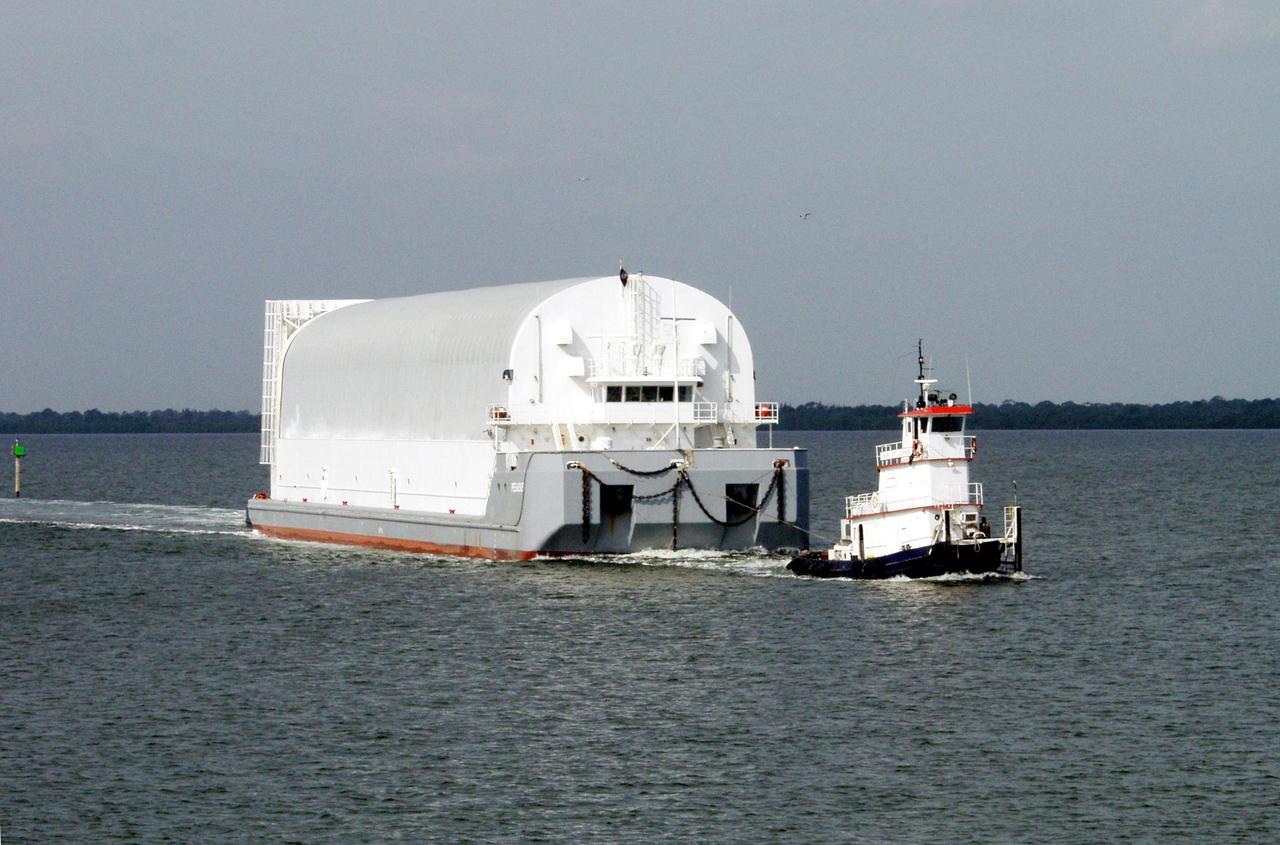 KENNEDY SPACE CENTER, FLA. -- A tug boat tows a newly arrived external tank in the Banana River to its offloading site. External tanks are built by the NASA Michoud Assembly Facility in New Orleans and transported by barge to Cape Canaveral and then up the Banana River to the turn basin in the Launch Complex 39 Area. From there it will be transported to the Vehicle Assembly Building where the tank will await stacking for a future Shuttle mission