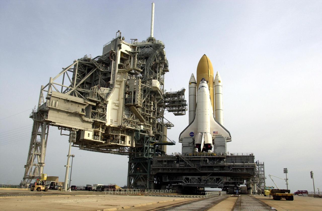 KENNEDY SPACE CENTER, FLA. --   Space Shuttle Endeavour rests on Launch Pad 39A after rollout from the Vehicle Assembly Building.  The Shuttle comprises the orbiter, in front, and the taller orange external tank behind it flanked by twin solid rocket boosters.  The Shuttle sits on the Mobile Launcher Platform that straddles the flame trench below.  On either side of Endeavour's tail and main engines are the tail service masts that support the fluid,, gas and electrical requirements of the orbiter's liquid oxyen and liquid hydrogen aft T-0 umbilicals. At left is the open Rotating Service Structure and the Fixed Service Structure to its right, with its 80-foot lightning mast on top. Mission STS-111 is designated UF-2, the 14th assembly flight to the International Space Station.  Endeavour's payload includes the Multi-Purpose Logistics Module Leonardo and Mobile Base System.  The mission also will swap resident crews on the Station, carrying the Expedition 5 crew and returning to Earth Expedition 4.  Liftoff of Endeavour is scheduled between 4 and 8 p.m. May 30, 2002