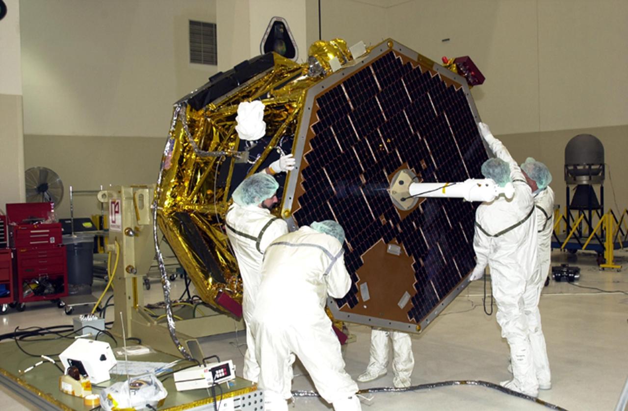 KENNEDY SPACE CENTER, FLA. -- Workers attach the solar panel and attached antenna to the Comet Nucleus Tour (CONTOUR) spacecraft in the Spacecraft Assembly and Encapsulation Facility 2 (SAEF-2). Scheduled for launch July 1, 2002, from LC 17A at Cape Canaveral Air Force Station, CONTOUR will provide the first detailed look into the heart of a comet -- the nucleus. The spacecraft will fly as close as 60 miles (100 kilometers) to at least two comets, Encke and Schwassmann-Wachmann 3. It will take the sharpest pictures yet of the nucleus while analyzing the gas and dust that surround these rocky, icy building blocks of the solar system. The Applied Physics Laboratory of Johns Hopkins University, Baltimore, Md., built CONTOUR and will also be in control of the spacecraft after launch