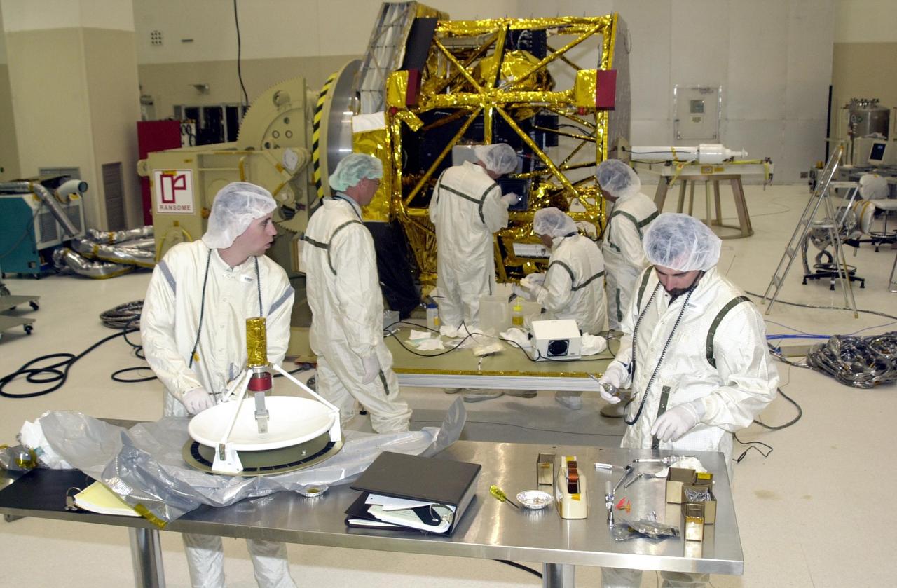 KENNEDY SPACE CENTER, FLA. -- Workers prepare the high gain antenna (foreground, on table) for installation on the Comet Nucleus Tour (CONTOUR) spacecraft in the Spacecraft Assembly and Encapsulation Facility 2 (SAEF-2). This second antenna will be installed near the larger antenna already attached. CONTOUR, scheduled for launch July 1, 2002, from LC 17A at Cape Canaveral Air Force Station, will provide the first detailed look into the heart of a comet -- the nucleus. The spacecraft will fly as close as 60 miles (100 kilometers) to at least two comets, Encke and Schwassmann-Wachmann 3. It will take the sharpest pictures yet of the nucleus while analyzing the gas and dust that surround these rocky, icy building blocks of the solar system. The Applied Physics Laboratory of Johns Hopkins University, Baltimore, Md., built CONTOUR and will also be in control of the spacecraft after launch