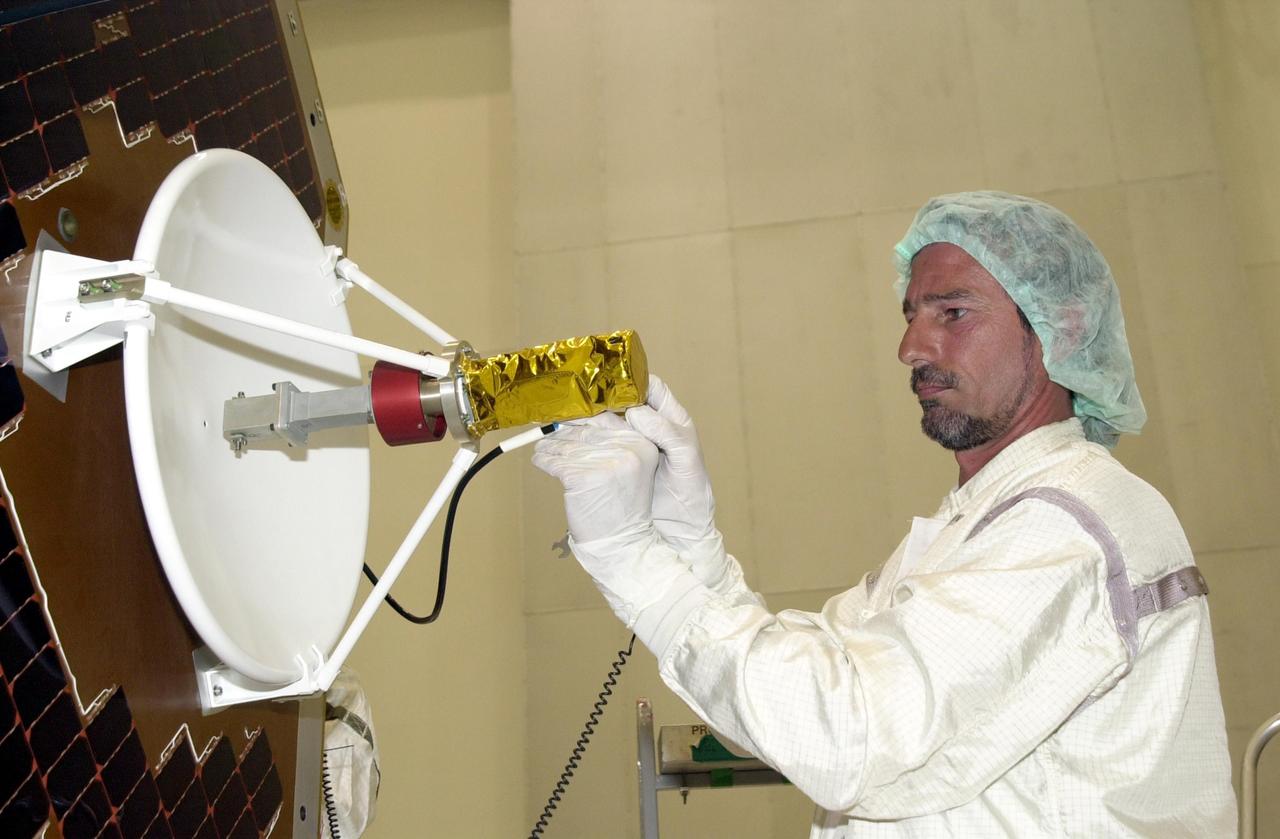KENNEDY SPACE CENTER, FLA. -- In the Spacecraft Assembly and Encapsulation Facility 2 (SAEF-2), a worker makes a final adjustment to the high gain antenna just installed on the solar panel of the Comet Nucleus Tour (CONTOUR) spacecraft. Scheduled for launch July 1, 2002, from LC 17A at Cape Canaveral Air Force Station, CONTOUR will provide the first detailed look into the heart of a comet -- the nucleus. The spacecraft will fly as close as 60 miles (100 kilometers) to at least two comets, Encke and Schwassmann-Wachmann 3. It will take the sharpest pictures yet of the nucleus while analyzing the gas and dust that surround these rocky, icy building blocks of the solar system. The Applied Physics Laboratory of Johns Hopkins University, Baltimore, Md., built CONTOUR and will also be in control of the spacecraft after launch