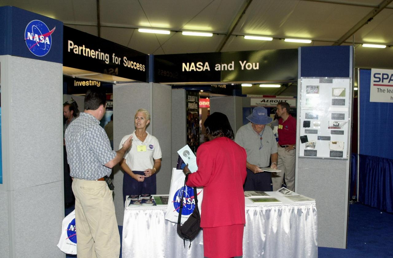 KENNEDY SPACE CENTER, FLA. -- At the 2002 Space Congress, Cape Canaveral, Fla., held April 30 - May 3, visitors stop by the NASA display booth. The Space Congress is held annually to highlight military and space initiatives, new technologies, and Florida's role in programs and research. This year's theme is Beginning a New Era - Initiatives in Space. NASA presented several paper sessions, including Hubble Discoveries and Advancements in Technology. Space Congress is sponsored by the Canaveral Council of Technical Societies