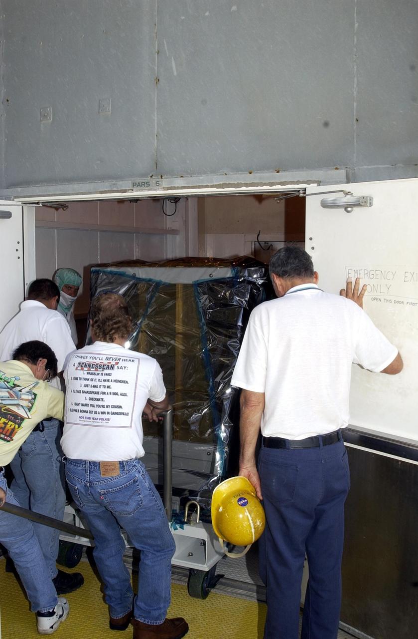 KENNEDY SPACE CENTER, FLA. -- Technicians prepare to install the replacement wrist joint for the Space Station Remote Manipulator System into Space Shuttle Endeavour's payload bay. The new wrist joint, called an Orbital Replacement Unit (ORU), will be installed next to the arm's Latching End Effector during the final of three planned spacewalks. Mission STS-111 is designated UF-2, the 14th assembly flight to the International Space Station. Endeavour's payload includes the Multi-Purpose Logistics Module Leonardo and Mobile Base System. The mission also will swap resident crews on the Station, carrying the Expedition 5 crew and returning to Earth Expedition 4. Liftoff of Endeavour is scheduled between 4 and 8 p.m. May 30, 2002