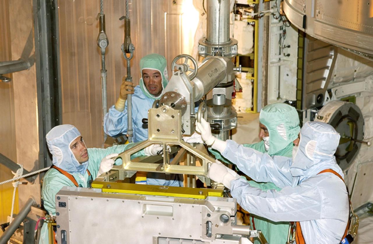 KENNEDY SPACE CENTER, FLA. -- At Pad 39A, technicians install the replacement wrist joint for the Space Station Remote Manipulator System into Space Shuttle Endeavour's payload bay. The new wrist joint, called an Orbital Replacement Unit (ORU), will be installed next to the arm's Latching End Effector during the final of three planned spacewalks. Mission STS-111 is designated UF-2, the 14th assembly flight to the International Space Station. Endeavour's payload includes the Multi-Purpose Logistics Module Leonardo and Mobile Base System. The mission also will swap resident crews on the Station, carrying the Expedition 5 crew and returning to Earth Expedition 4. Liftoff of Endeavour is scheduled between 4 and 8 p.m. May 30, 2002