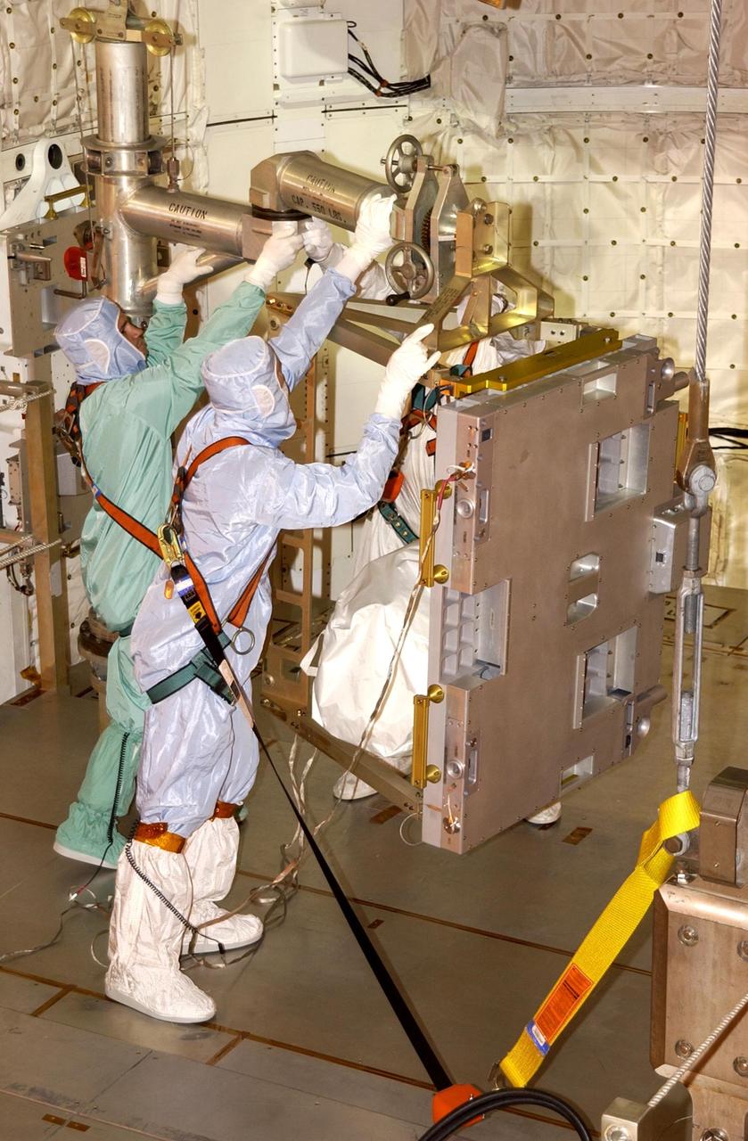 KENNEDY SPACE CENTER, FLA. -- At Pad 39A, technicians install the replacement wrist joint for the Space Station Remote Manipulator System into Space Shuttle Endeavour's payload bay. The new wrist joint, called an Orbital Replacement Unit (ORU), will be installed next to the arm's Latching End Effector during the final of three planned spacewalks. Mission STS-111 is designated UF-2, the 14th assembly flight to the International Space Station. Endeavour's payload includes the Multi-Purpose Logistics Module Leonardo and Mobile Base System. The mission also will swap resident crews on the Station, carrying the Expedition 5 crew and returning to Earth Expedition 4. Liftoff of Endeavour is scheduled between 4 and 8 p.m. May 30, 2002