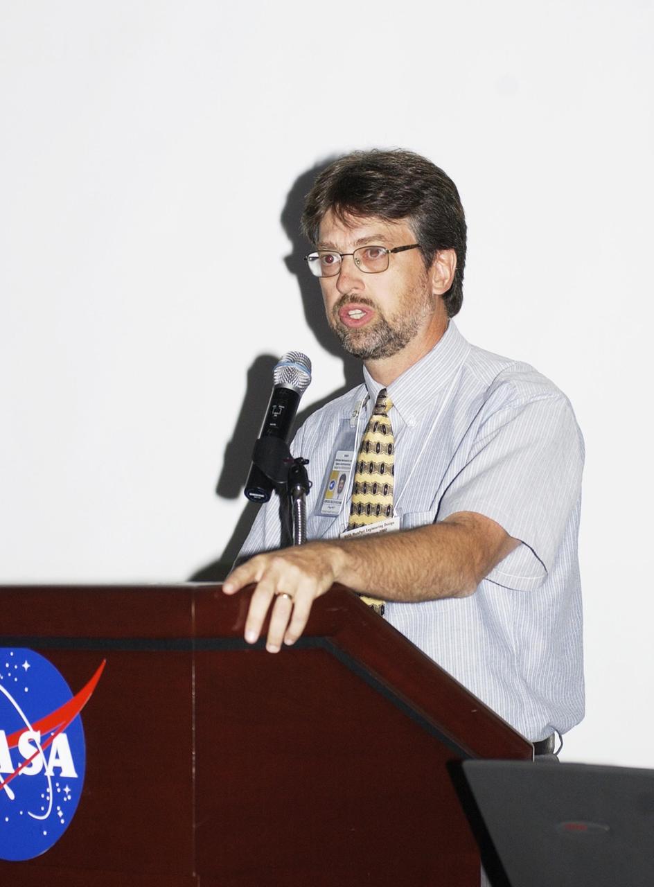 KENNEDY SPACE CENTER, FLA. --  Gregg Buckingham, with KSC's Center for Space Education, addresses participants in this year's NASA MarsPort Engineering Design Student Competition 2002 conference at the KSC Visitor Complex, organized by the Florida Space Grant Consortium.  Students and faculty from the nation's universities converged at Kennedy for the MarsPort Competition, presenting papers on engineering trade studies to design optimal configurations for a MarsPort Deployable Greenhouse for operation on the surface of Mars.  Judges in the competition were from KSC, Dynamac Corporation and Florida Institute of Technology.   The winning team's innovative ideas will be used by NASA to evaluate and study other engineering trade concepts.  Also featured at the opening ceremony were Dr. Sam Durrance, FSGC director and former astronaut, and Dr. Gary Stutte, plant scientist, Dynamac Corporation. 