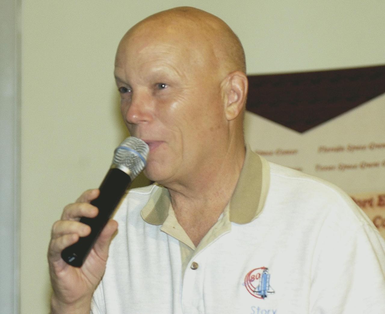 KENNEDY SPACE CENTER, FLA. --  Former astronaut Story Musgrave speaks to students and faculty from across the nation gathered at the KSC Visitor Complex for this year's NASA MarsPort Engineering Design Student Competition 2002 conference.   The participants are presenting papers on engineering trade studies to design optimal configurations for a MarsPort Deployable Greenhouse for operation on the surface of Mars.  Judges in the competition were from KSC, Dynamac Corporation and Florida Institute of Technology.   The winning team's innovative ideas will be used by NASA to evaluate and study other engineering trade concepts. Featured at the opening ceremony were Dr. Sam Durrance, FSGC director and former astronaut, and Dr. Gary Stutte, plant scientist, Dynamac Corporation. 