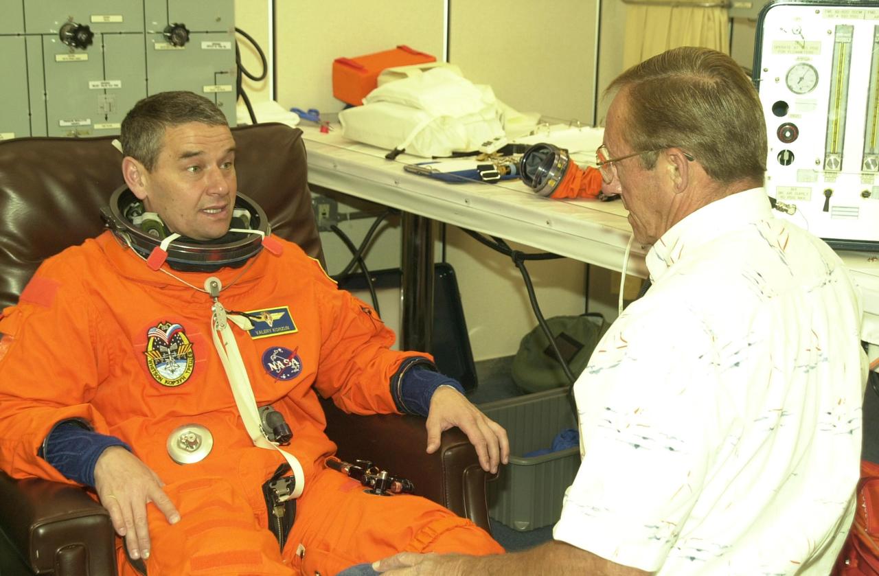 KENNEDY SPACE CENTER, FLA. -- During suit check, Expedition 5 Commander Valeri Korzun talks to a technician. The suit check is part of Terminal Countdown Demonstration Test activities at KSC. The TCDT includes emergency egress training at the pad and a simulated launch countdown. Expedition 5 will travel to the International Space Stationon mission STS-111 as the replacement crew for Expedition 4, who will return to Earth aboard Endeavour. Known as Utilization Flight -2, the mission includes attaching a Canadian-built mobile base system to the International Space Station that will enable the Canadarm2 robotic arm to move along a railway on the Station's truss to build and maintain the outpost. The crew will also replace a faulty wrist/roll joint on the Canadarm2 as well as unload almost three tons of experiments and supplies from the Italian-built Multi-Purpose Logistics Module Leonardo. Launch of Space Shuttle Endeavour on mission STS-111 is scheduled for May 30, 2002