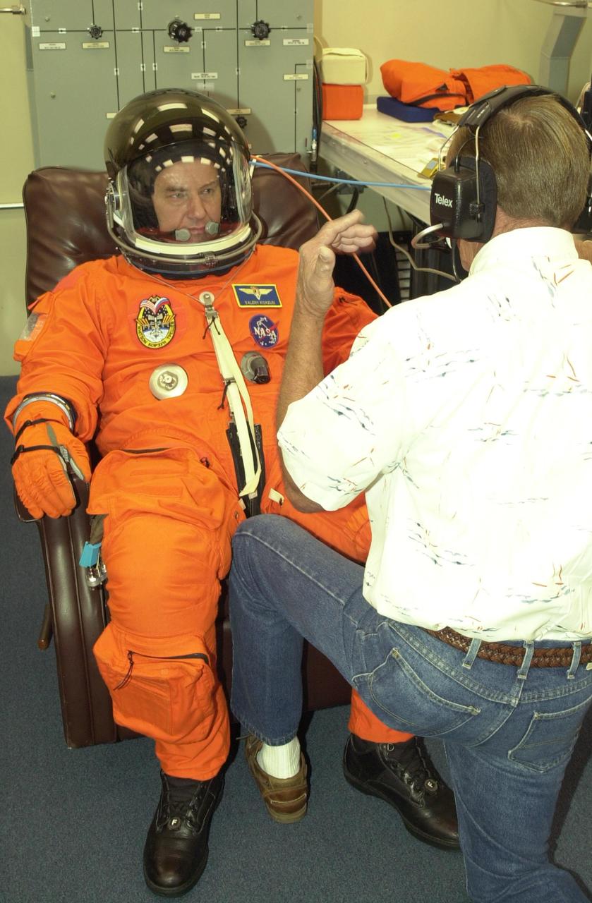 KENNEDY SPACE CENTER, FLA. -- During suit check, Expedition 5 Commander Valeri Korzun talks to a technician. The suit check is part of Terminal Countdown Demonstration Test activities at KSC. The TCDT includes emergency egress training at the pad and a simulated launch countdown. Expedition 5 will travel to the International Space Station on mission STS-111 as the replacement crew for Expedition 4, who will return to Earth aboard Endeavour. Known as Utilization Flight -2, the mission includes attaching a Canadian-built mobile base system to the International Space Station that will enable the Canadarm2 robotic arm to move along a railway on the Station's truss to build and maintain the outpost. The crew will also replace a faulty wrist/roll joint on the Canadarm2 as well as unload almost three tons of experiments and supplies from the Italian-built Multi-Purpose Logistics Module Leonardo. Launch of Space Shuttle Endeavour on mission STS-111 is scheduled for May 30, 2002