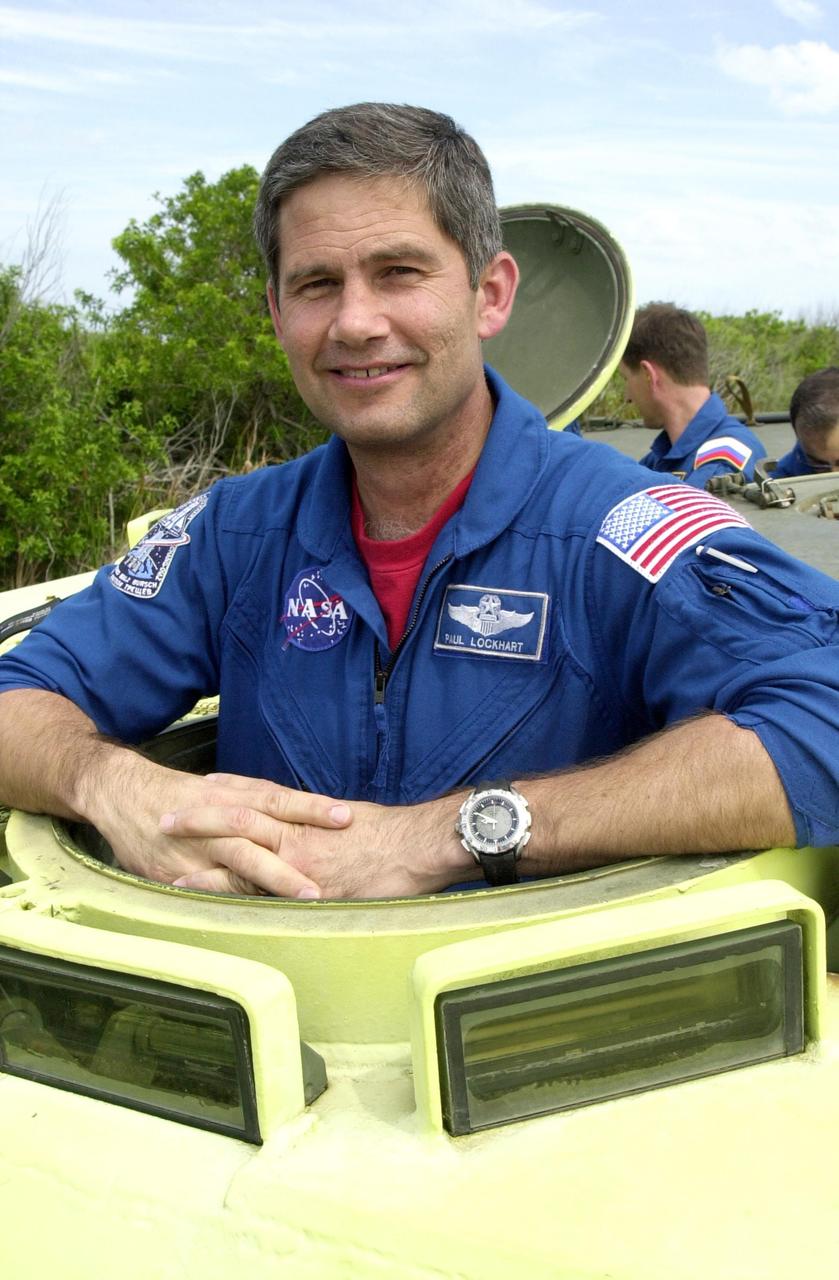 KENNEDY SPACE CENTER, FLA. -- STS-111 Pilot Paul Lockhart poses for the camera before taking his turn at driving the M-113 armored personnel carrier during emergency egress training at the pad. The training is part of Terminal Countdown Demonstration Test activities at KSC. The TCDT also includes a simulated launch countdown. Known as Utilization Flight -2, the mission includes attaching a Canadian-built mobile base system to the International Space Station that will enable the Canadarm2 robotic arm to move along a railway on the Station's truss to build and maintain the outpost. The crew will also replace a faulty wrist/roll joint on the Canadarm2 as well as unload almost three tons of experiments and supplies from the Italian-built Multi-Purpose Logistics Module Leonardo. Launch of Space Shuttle Endeavour on mission STS-111 is scheduled for May 30, 2002