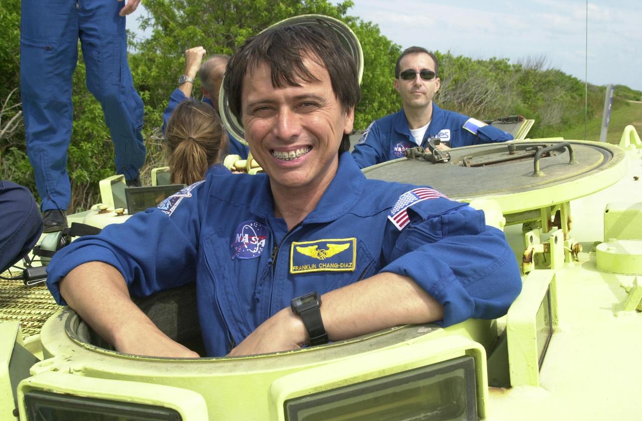 KENNEDY SPACE CENTER, FLA. -- STS-111 Mission Specialist Franklin Chang-Diaz poses for the camera before taking his turn at driving the M-113 armored personnel carrier during emergency egress training at the pad. Behind him (right) is Mission Specialist Philippe Perrin, with the French Space Agency. The training is part of Terminal Countdown Demonstration Test activities at KSC. The TCDT also includes a simulated launch countdown. Known as Utilization Flight -2, the mission includes attaching a Canadian-built mobile base system to the International Space Station that will enable the Canadarm2 robotic arm to move along a railway on the Station's truss to build and maintain the outpost. The crew will also replace a faulty wrist/roll joint on the Canadarm2 as well as unload almost three tons of experiments and supplies from the Italian-built Multi-Purpose Logistics Module Leonardo. Launch of Space Shuttle Endeavour on mission STS-111 is scheduled for May 30, 2002
