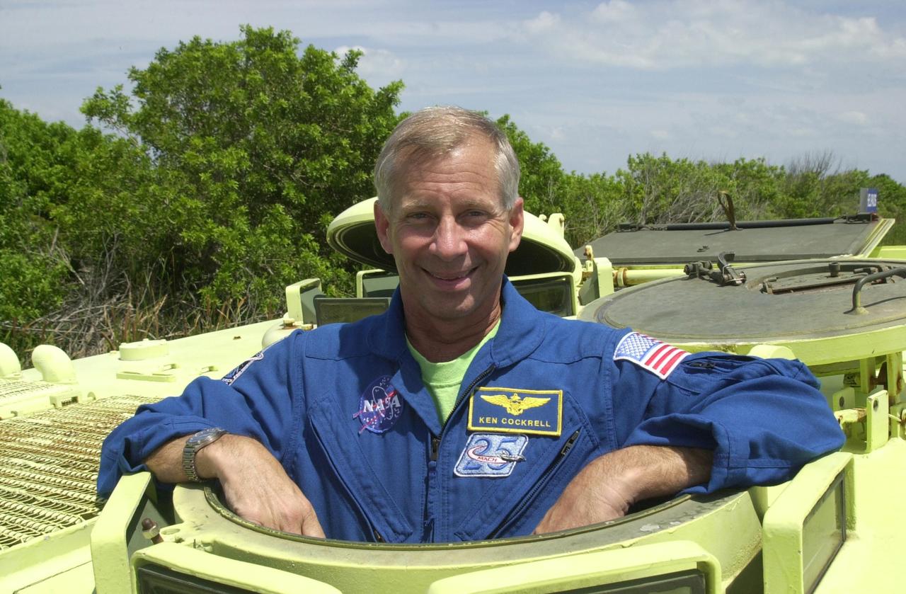 KENNEDY SPACE CENTER, FLA. - During Terminal Countdown Demonstration Test activities at KSC, STS-111 Commander Kenneth Cockrell poses for the camera before taking his turn driving the M-113 armored personnel carrier, part of emergency egress training at the pad. The TCDT includes emergency egress training at the pad and a simulated launch countdown Known as Utilization Flight -2, the mission includes attaching a Canadian-built mobile base system to the International Space Station that will enable the Canadarm2 robotic arm to move along a railway on the Station's truss to build and maintain the outpost. The crew will also replace a faulty wrist/roll joint on the Canadarm2 as well as unload almost three tons of experiments and supplies from the Italian-built Multi-Purpose Logistics Module Leonardo. . Expedition 5 will travel to the International Space Station on mission STS-111 as the replacement crew for Expedition 4, who will return to Earth aboard Endeavour. Launch of Space Shuttle Endeavour on mission STS-111 is scheduled for May 30, 2002