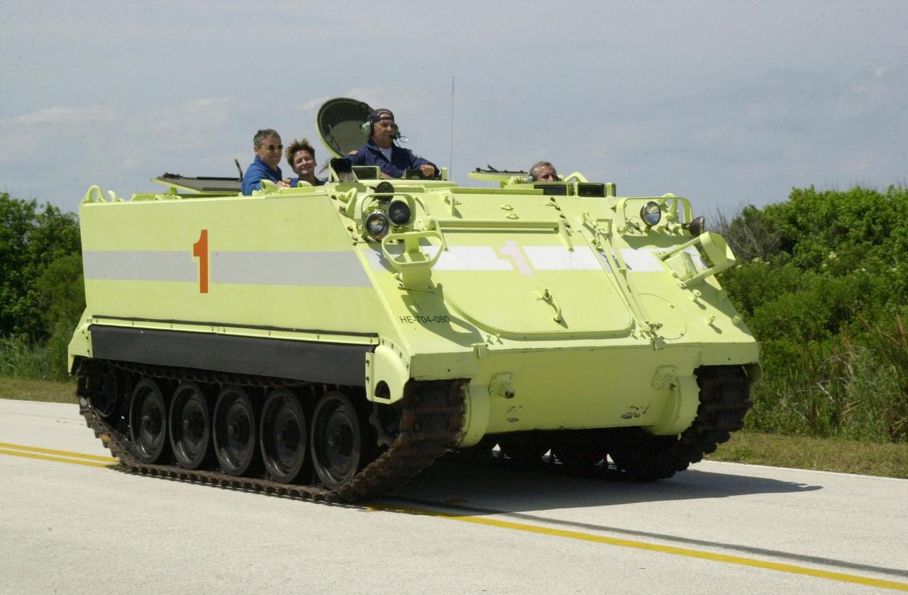 KENNEDY SPACE CENTER, FLA. - During Terminal Countdown Demonstration Test activities at KSC, STS-11 Commander Kenneth Cockrell practices driving the M-113 armored personnel carrier, part of emergency egress training at the pad. Supervising in front (left) is George Hoggard, with the KSC/CCAS Fire Department, who supervises the driving. Passengers in the M-113 (behind Hoggard) are Expedition 5 crew members Valeri Korzun and Peggy Whitson. The TCDT also includes a simulated launch countdown Known as Utilization Flight -2, the mission includes attaching a Canadian-built mobile base system to the International Space Station that will enable the Canadarm2 robotic arm to move along a railway on the Station's truss to build and maintain the outpost. The crew will also replace a faulty wrist/roll joint on the Canadarm2 as well as unload almost three tons of experiments and supplies from the Italian-built Multi-Purpose Logistics Module Leonardo. . Expedition 5 will travel to the International Space Station on mission STS-111 as the replacement crew for Expedition 4, who will return to Earth aboard Endeavour. Launch of Space Shuttle Endeavour on mission STS-111 is scheduled for May 30, 2002