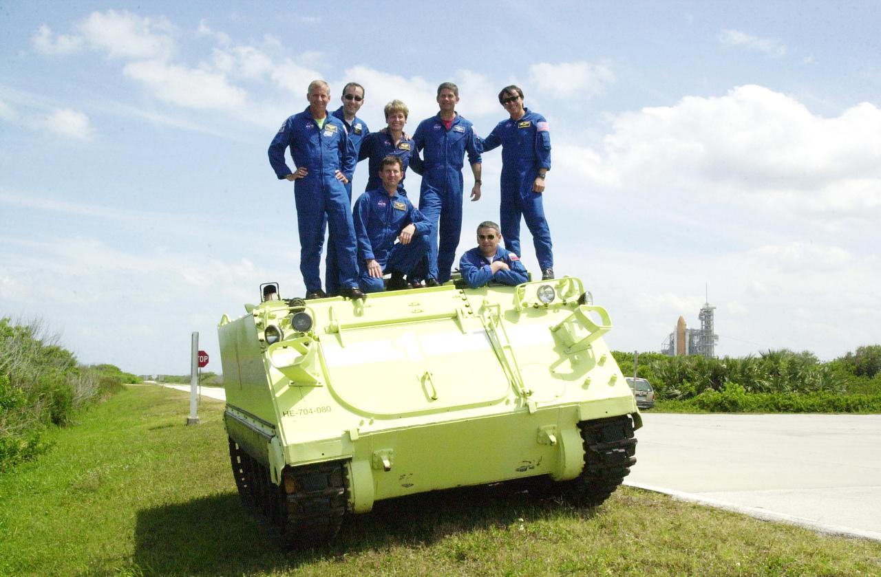 KENNEDY SPACE CENTER, FLA. - The STS-111 and Expedition 5 crews pose on top of the M-113 armored personnel carrier they practiced driving during emergency egress training at the pad. Standing, left to right, are Mission Commander Kenneth Cockrell, Mission Specialist Philippe Perrin, Expedition 5 member Peggy Whitson, Pilot Paul Lockhart and Mission Specialist Franklin Chang-Diaz; in front are Expedition 5 members Sergei Treschev (left) and Commander Valeri Korzun (right). The crews are taking part in Terminal Countdown Demonstration Test activities at KSC, which include a simulated launch countdown. Expedition 5 will travel to the International Space Station on mission STS-111 as the replacement crew for Expedition 4, who will return to Earth aboard Endeavour. Known as Utilization Flight -2, the mission includes attaching a Canadian-built mobile base system to the International Space Station that will enable the Canadarm2 robotic arm to move along a railway on the Station's truss to build and maintain the outpost. The crew will also replace a faulty wrist/roll joint on the Canadarm2 as well as unload almost three tons of experiments and supplies from the Italian-built Multi-Purpose Logistics Module Leonardo. Launch of Space Shuttle Endeavour on mission STS-111 is scheduled for May 30, 2002