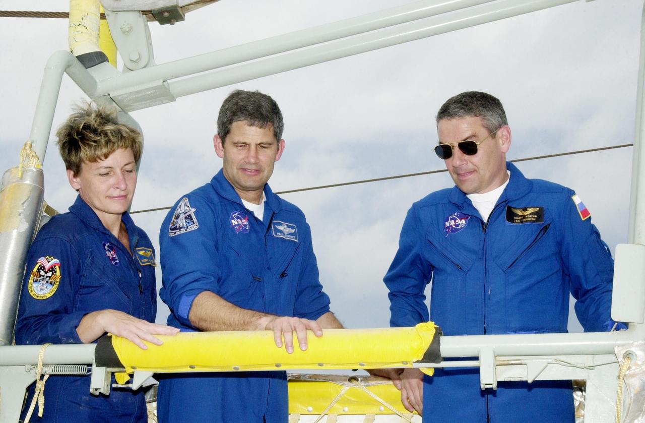 KENNEDY SPACE CENTER, FLA. -- During emergency egress training at the pad, Expedition 5 member Peggy Whitson, STS-111 Pilot Paul Lockhart and Expedition 5 Commander Valeri Korzun look over the slidewire basket area. The training for the two crews is part of Terminal Countdown Demonstration Test activities, which also include a simulated launch countdown. Mission STS-111 is known as Utilization Flight 2, carrying supplies and equipment in the Multi-Purpose Logistics Module Leonardo to the International Space Station. The payload also includes the Mobile Base System, which will be installed on the Mobile Transporter to complete the Canadian Mobile Servicing System, or MSS, and a replacement wrist/roll joint for Canadarm 2. The mechanical arm will then have the capability to "inchworm" from the U.S. Lab Destiny to the MSS and travel along the truss to work sites. Expedition 5 will travel to the Station on Endeavour as the replacement crew for Expedition 4, who will return to Earth aboard the orbiter. Launch is scheduled for May 30, 2002