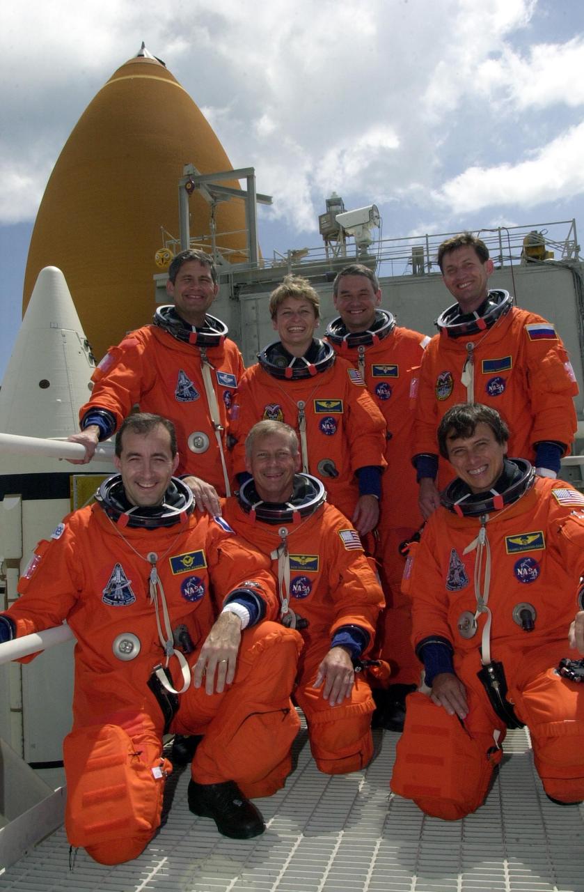 KENNEDY SPACE CENTER, FLA. -- During Terminal Countdown Demonstration Test activities at Launch Pad 39A, the Expedition 5 and STS-111 crews pose on the 295-foot level. Standing, left to right, are Pilot Paul Lockhart, and the Expedition 5 crew Peggy Whitson, Commander Valeri Korzun and Sergei Treschev. Kneeling in front are Mission Specialist Philippe Perrin, Commander Kenneth Cockrell and Mission Specialist Franklin Chang-Diaz. Korzun and Treschev are with the Russian Space Agency, and Perrin is with the French Space Agency. Seen behind the crews are the top of the orange external tank and one of the white solid rocket boosters. The TCDT includes emergency egress training at the pad and a simulated launch countdown. Mission STS-111 is known as Utilization Flight 2, carrying supplies and equipment in the Multi-Purpose Logistics Module Leonardo to the International Space Station. The payload also includes the Mobile Base System, which will be installed on the Mobile Transporter to complete the Canadian Mobile Servicing System, or MSS, and a replacement wrist/roll joint for Canadarm 2. The mechanical arm will then have the capability to "inchworm" from the U.S. Lab Destiny to the MSS and travel along the truss to work sites. Expedition 5 will travel to the Station on Endeavour as the replacement crew for Expedition 4, who will return to Earth aboard the orbiter. Launch is scheduled for May 30, 2002