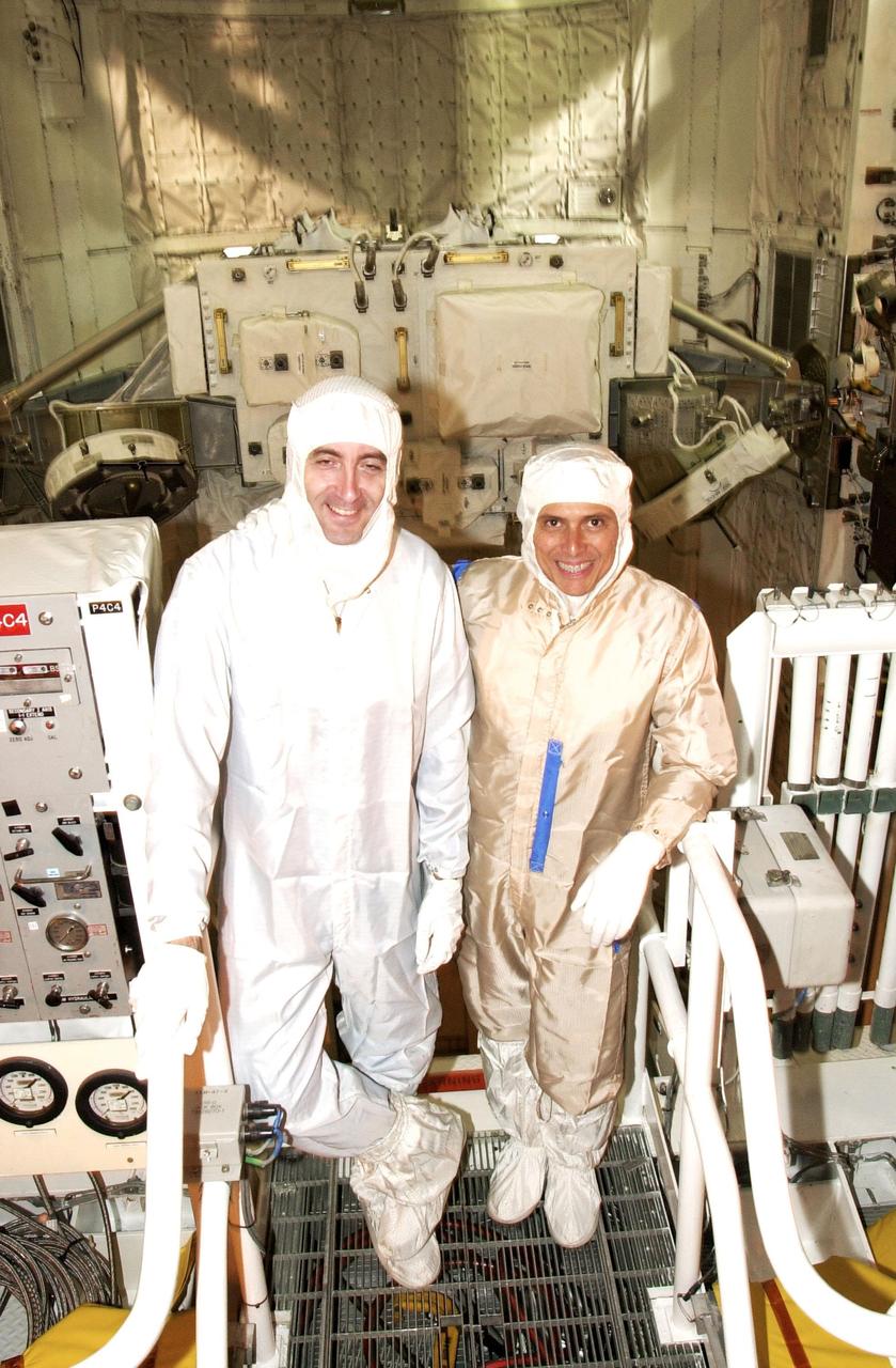 KENNEDY SPACE CENTER, FLA. -- In the Orbiter Processing Facility, STS-111 Mission Specialists Philippe Perrin, with the French Space Agency, and Franklin Chang-Diaz pause during their checkout of the payload installed in Endeavour's payload bay.  The crew is at KSC for Terminal Countdown Demonstration Test activities, which include payload familiarization and a simulated launch countdown.  The crew also comprises Commander Kenneth Cockrell and Pilot Paul Lockhart.  The payload on the mission to the International Space Station includes the Mobile Base System, an Orbital Replacement Unit and Multi-Purpose Logistics Module Leonardo.   Traveling on Endeavour is also the Expedition 5 crew - Commander Valeri Korzun, Peggy Whitson and Sergei Treschev -- who will replace the Expedition 4 crew on the Station.  Korzun and Treschev are with the Russian Space Agency.  Launch of Endeavour is scheduled for May 30, 2002.