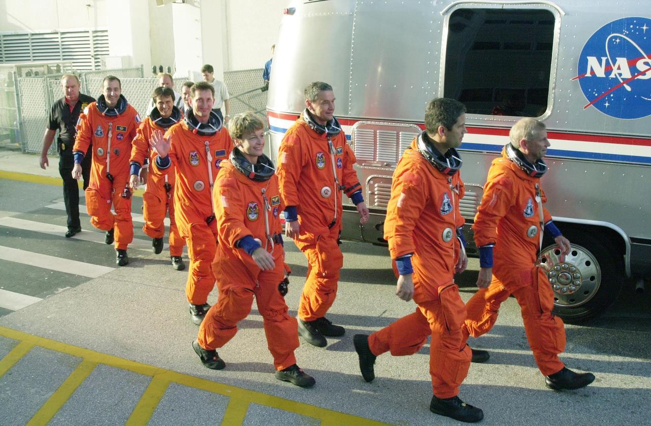 KENNEDY SPACE CENTER, FLA. -- The STS-111 crew and Expedition 5 walk eagerly to the Astrovan that will take them to Launch Pad 39A for a simulated countdown. From left are Mission Specialists Philippe Perrin and Franklin Chang-Diaz; the Expedition 5 crew, Sergei Treschev, Peggy Whitson and Valeri Korzun; Pilot Paul Lockhart; and Commander Kenneth Cockrell. The simulation is part of STS-111 Terminal Countdown Demonstration Test activities for the crew and Expedition 5. The payload on the mission to the International Space Station includes the Mobile Base System (MBS), an Orbital Replacement Unit and Multi-Purpose Logistics Module Leonardo. The MBS will be installed on the Mobile Transporter to complete the Canadian Mobile Servicing System, or MSS, enabling Canadarm 2 to "inchworm" from the U.S. Lab Destiny to the MSS and travel along the truss to work sites. The Expedition 5 crew is traveling on Endeavour to replace the Expedition 4 crew on the Station. Launch of Endeavour is scheduled for May 30, 2002