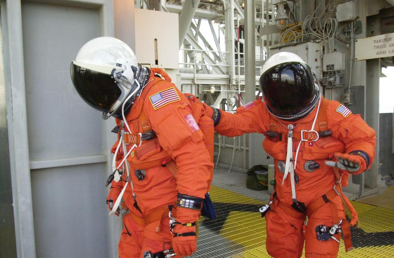 KENNEDY SPACE CENTER, FLA. --  STS-111 Commander Kenneth Cockrell (left) and Pilot Paul Lockhart practice making a hasty exit from the 195-foot level to the slidewire baskets in the event of an emergency.  They and the rest of the STS-111 crew and the Expedition 5 crew are taking part in Terminal Countdown Demonstration Test activities, which include emergency egress training and a simulated launch countdown.  Mission STS-111 is Utilization Flight 2, carrying equipment and supplies in the Multi-Purpose Logistics Module Leonardo to the International Space Station, plus the Mobile Base System (MBA) and an Orbital Replacement Unit.  The MBS will be installed on the Mobile Transporter to complete the Canadian Mobile Servicing System, or MSS, enabling Canadarm 2 to "inchworm" from the U.S. Lab Destiny to the MSS and travel along the truss to work sites.  The Expedition 5 crew is traveling on Endeavour to replace the Expedition 4 crew on the Station.  Launch of Endeavour is scheduled for May 30, 2002
