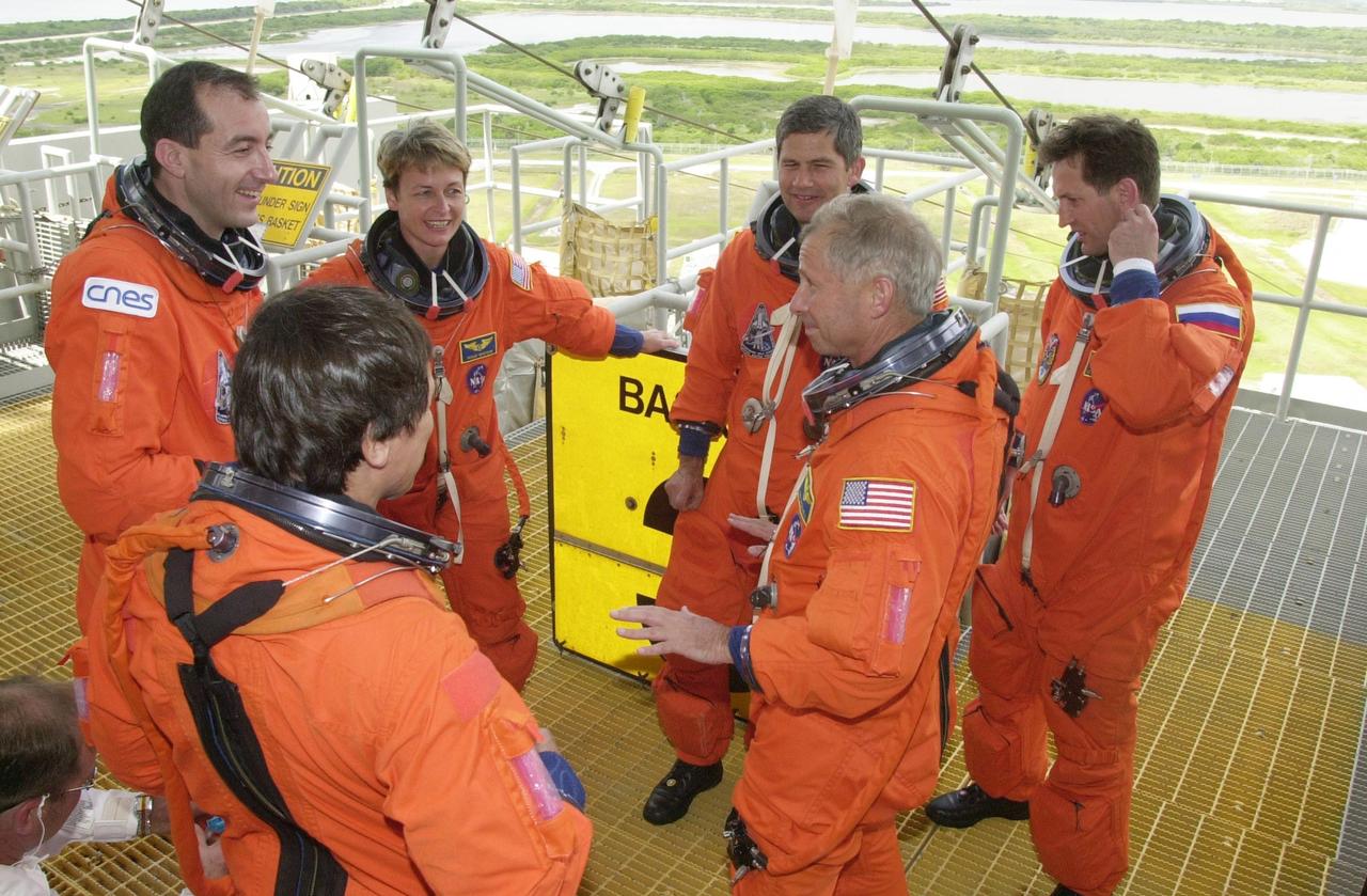 KENNEDY SPACE CENTER, FLA. --  At the 195-foot level of the Fixed Service Structure, the STS-111 and Expedition 5 crews relax after practicing emergency exit from the pad.  Clockwise from left are Mission Specialists Franklin Chang-Diaz (back to camera) and Philippe Perrin, Expedition 5 members Peggy Whitson, Valeri Korzun and Sergei Treschev, and Commander Kenneth Cockrell.  Pilot Paul Lockhart is not shown.  The two crews are taking part in Terminal Countdown Demonstration Test activities, which include emergency egress training and a simulated launch countdown.  Mission STS-111 is Utilization Flight 2, carrying equipment and supplies in the Multi-Purpose Logistics Module Leonardo to the International Space Station, plus the Mobile Base System (MBA) and an Orbital Replacement Unit.  The MBS will be installed on the Mobile Transporter to complete the Canadian Mobile Servicing System, or MSS, enabling Canadarm 2 to "inchworm" from the U.S. Lab Destiny to the MSS and travel along the truss to work sites.  The Expedition 5 crew is traveling on Endeavour to replace the Expedition 4 crew on the Station.  Launch of Endeavour is scheduled for May 30, 2002