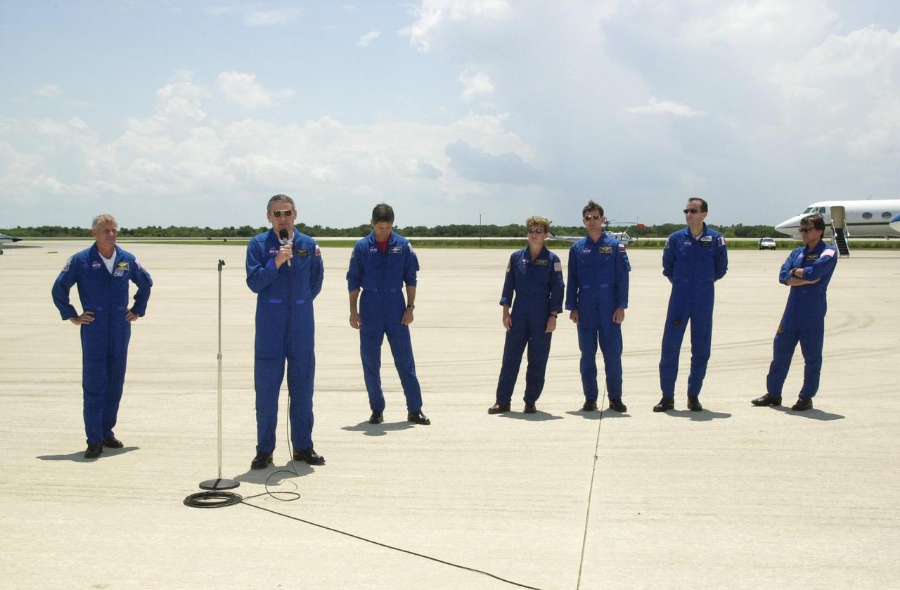 KENNEDY SPACE CENTER, FLA. -- Expedition 5 Commander Valeri Korzun (with microphone) speaks to the media before leaving KSC. Behind him (left to right) are STS-111 Commander Kenneth Cockrell and Pilot Paul Lockhart; astronaut Peggy Whitson and cosmonaut Sergei Treschev; Mission Specialists Philippe Perrin and Franklin Chang-Diaz. Korzun and Treschev are with the Russian Space Agency; Perrin is with the French Space Agency. They have been taking part in Terminal Countdown Demonstration Test activities that include emergency egress training and a simulated launch countdown. Expedition 5 will travel to the International Space Station on mission STS-111 as the replacement crew for Expedition 4, who will return to Earth aboard the orbiter. Mission STS-111 is known as Utilization Flight 2, carrying supplies and equipment in the Multi-Purpose Logistics Module Leonardo to the International Space Station. The payload also includes the Mobile Base System, which will be installed on the Mobile Transporter to complete the Canadian Mobile Servicing System, or MSS, and a replacement wrist/roll joint for Canadarm 2. The mechanical arm will then have the capability to "inchworm" from the U.S. Lab Destiny to the MSS and travel along the truss to work sites. Launch is scheduled for May 30, 2002