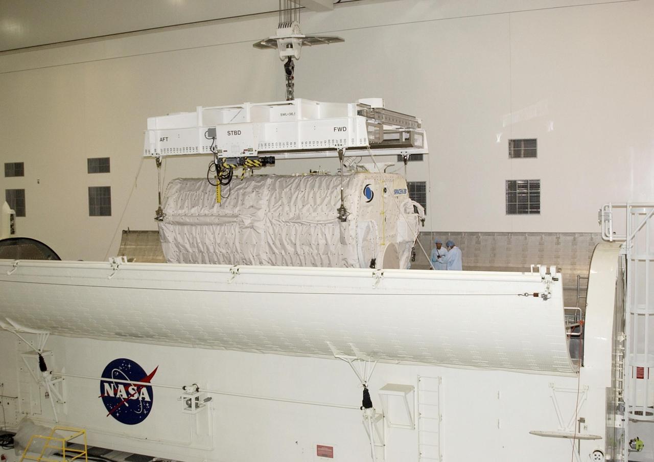 KENNEDY SPACE CENTER, FLA. -- In the Space Station Processing Facility, the overhead crane lowers the SHI Research Double Module (SHI/RDM) into the payload canister.  The canister will transport it to the Orbiter Processing Facility where it will be installed in Columbia's payload bay for mission STS-107. SHI/RDM is the primary payload of the research mission, with experiments ranging from material sciences to life sciences (many rats).  Also part of the payload is the Fast Reaction Experiments Enabling Science, Technology, Applications and Research (FREESTAR) that incorporates eight high priority secondary attached shuttle experiments.  STS-107 is scheduled to launch July 19, 2002